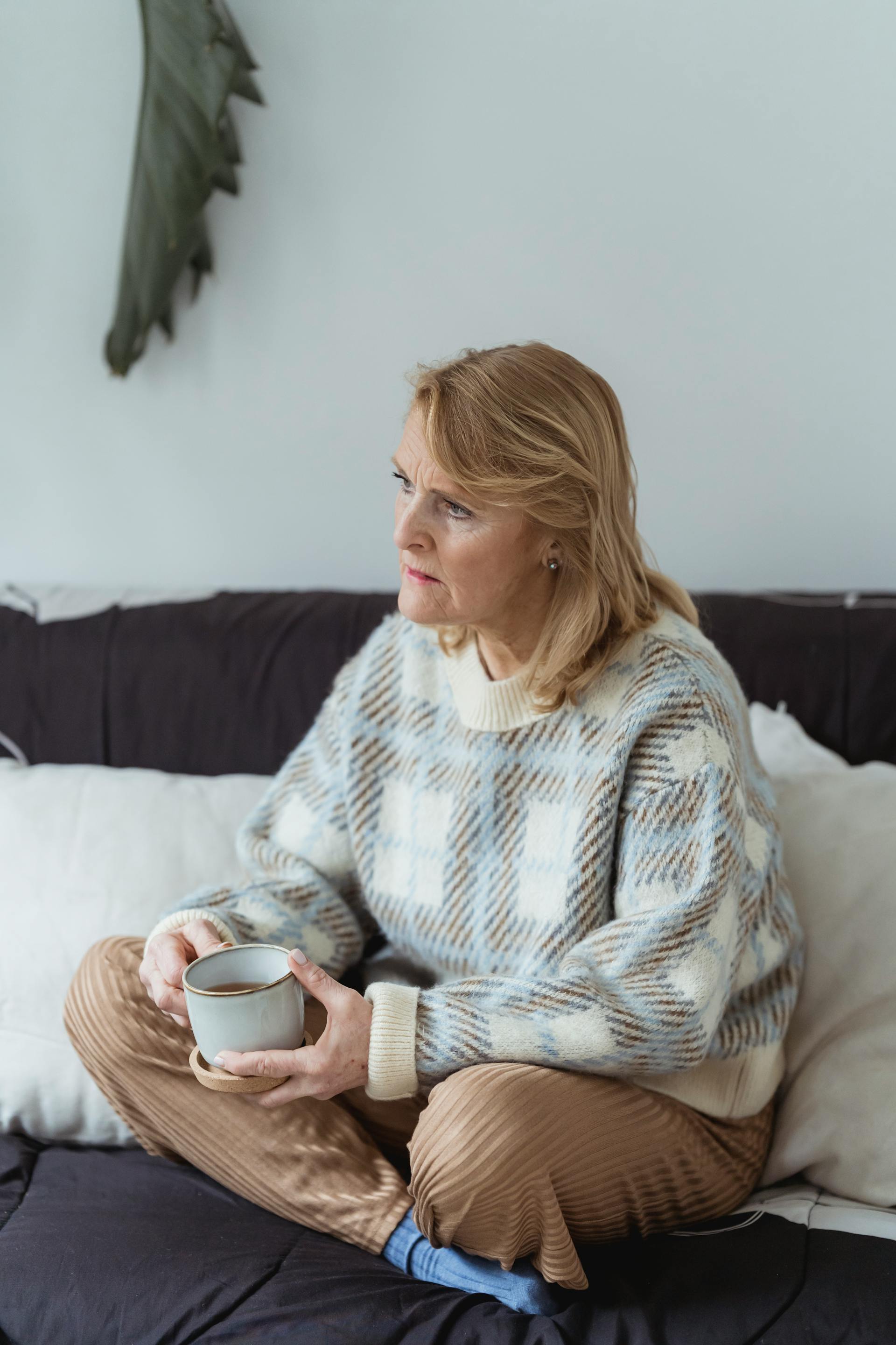 A middle-aged woman holding a mug and looking at someone | Source: Pexels
