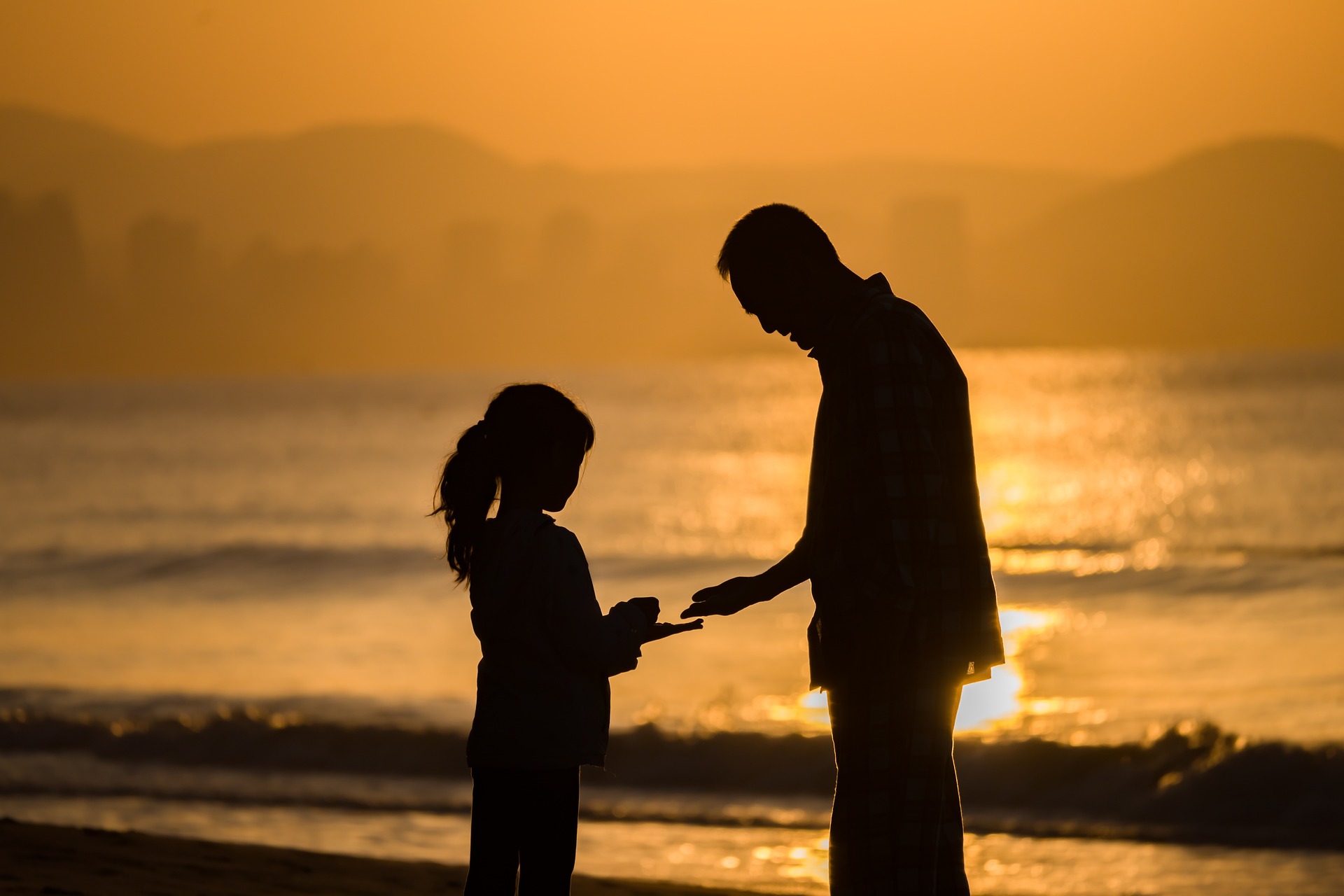 A father with his daughter at the beach | Source: Pixabay