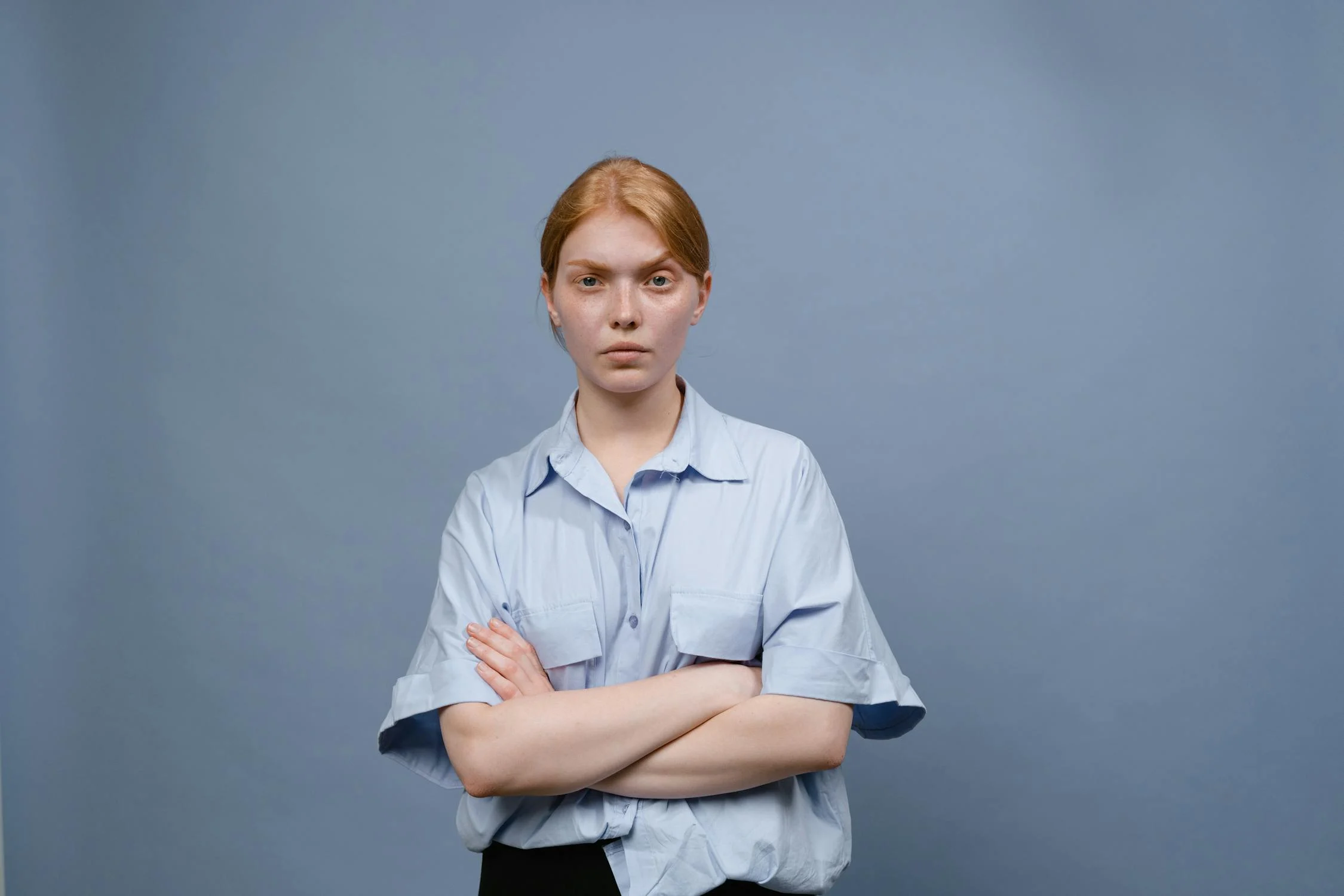 A serious woman with her arms crossed ⏐ Source: Pexels