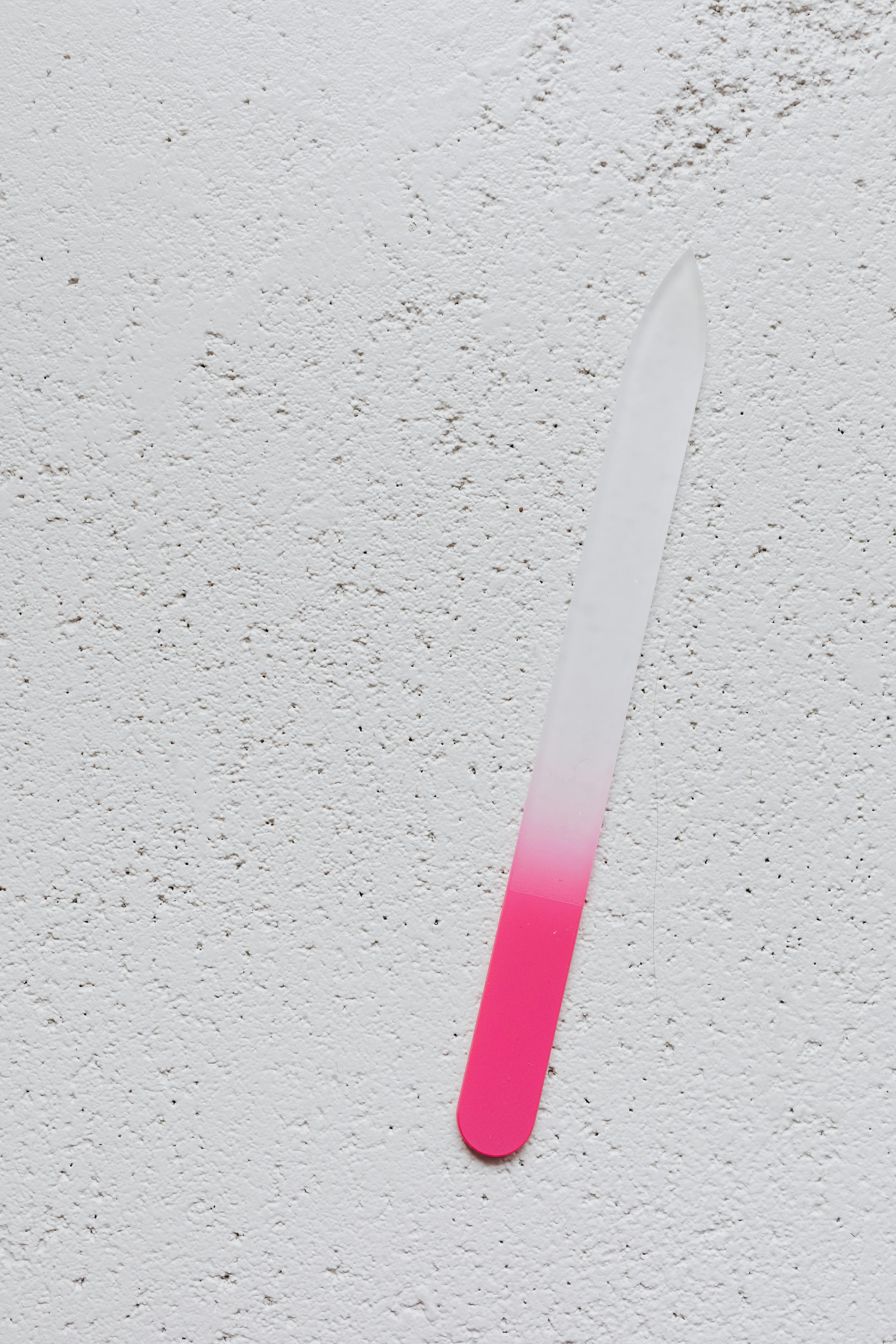 A pink and white nail file on a table | Source: Pexels