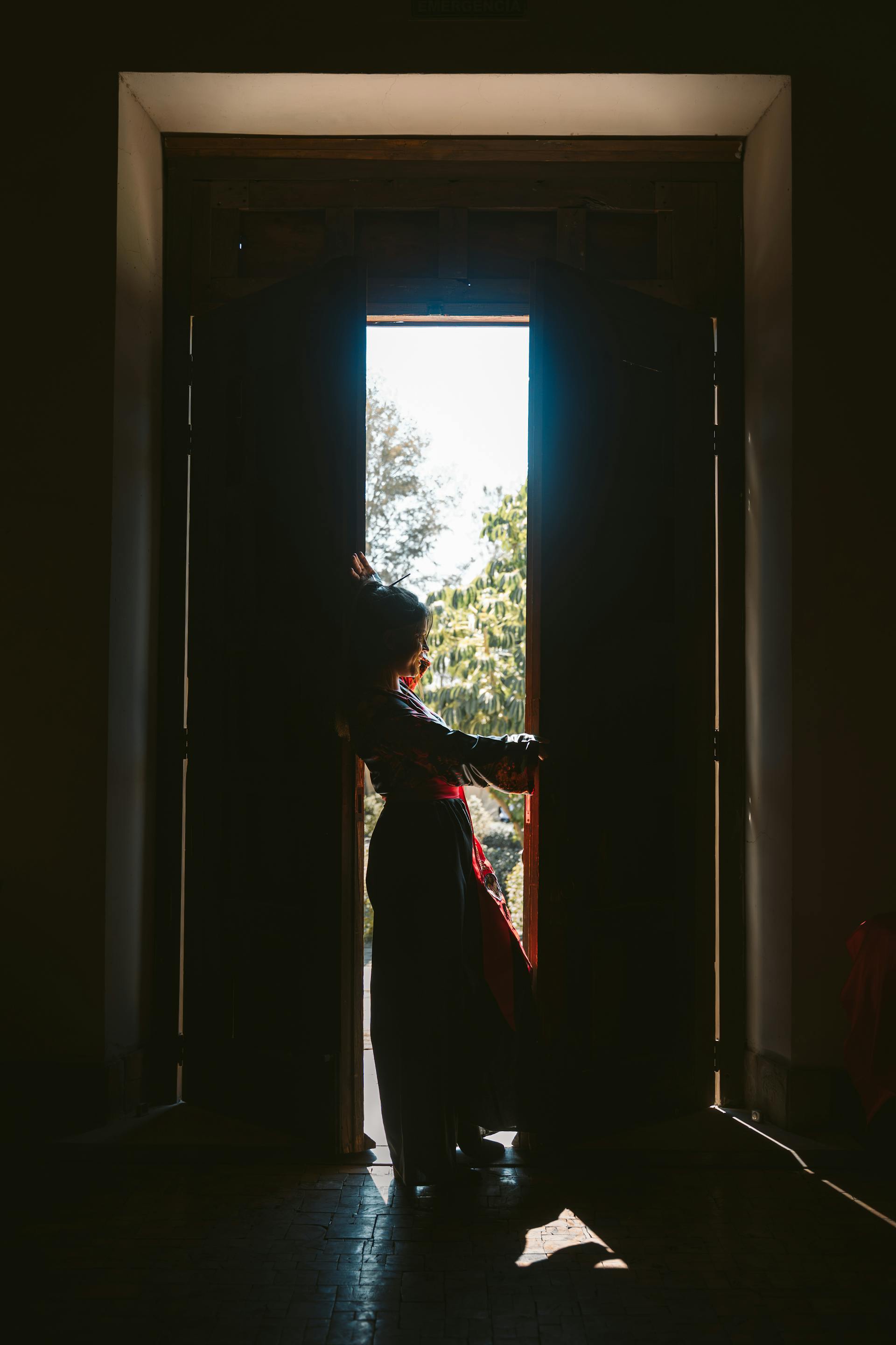 A woman silhouetted in a doorway | Source: Pexels