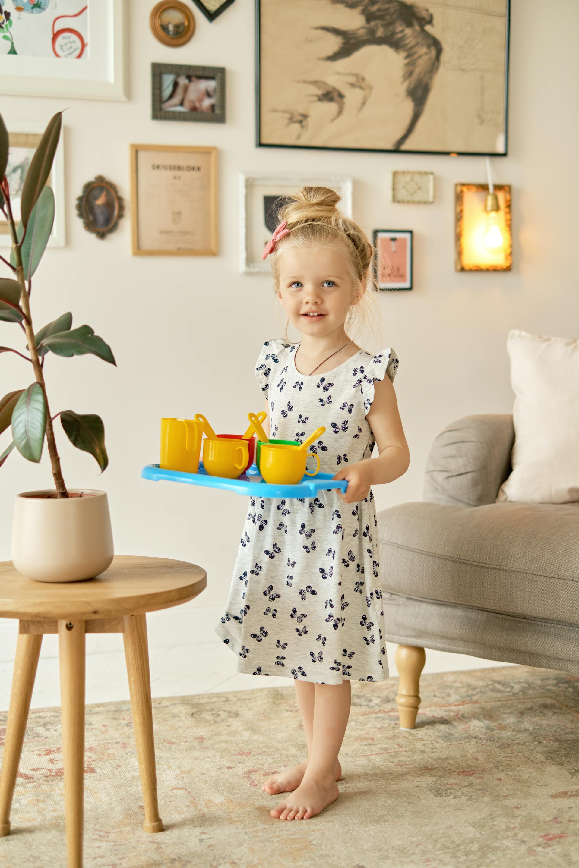 A young girl carrying plastic cups on a plastic tray | Source: Pexels