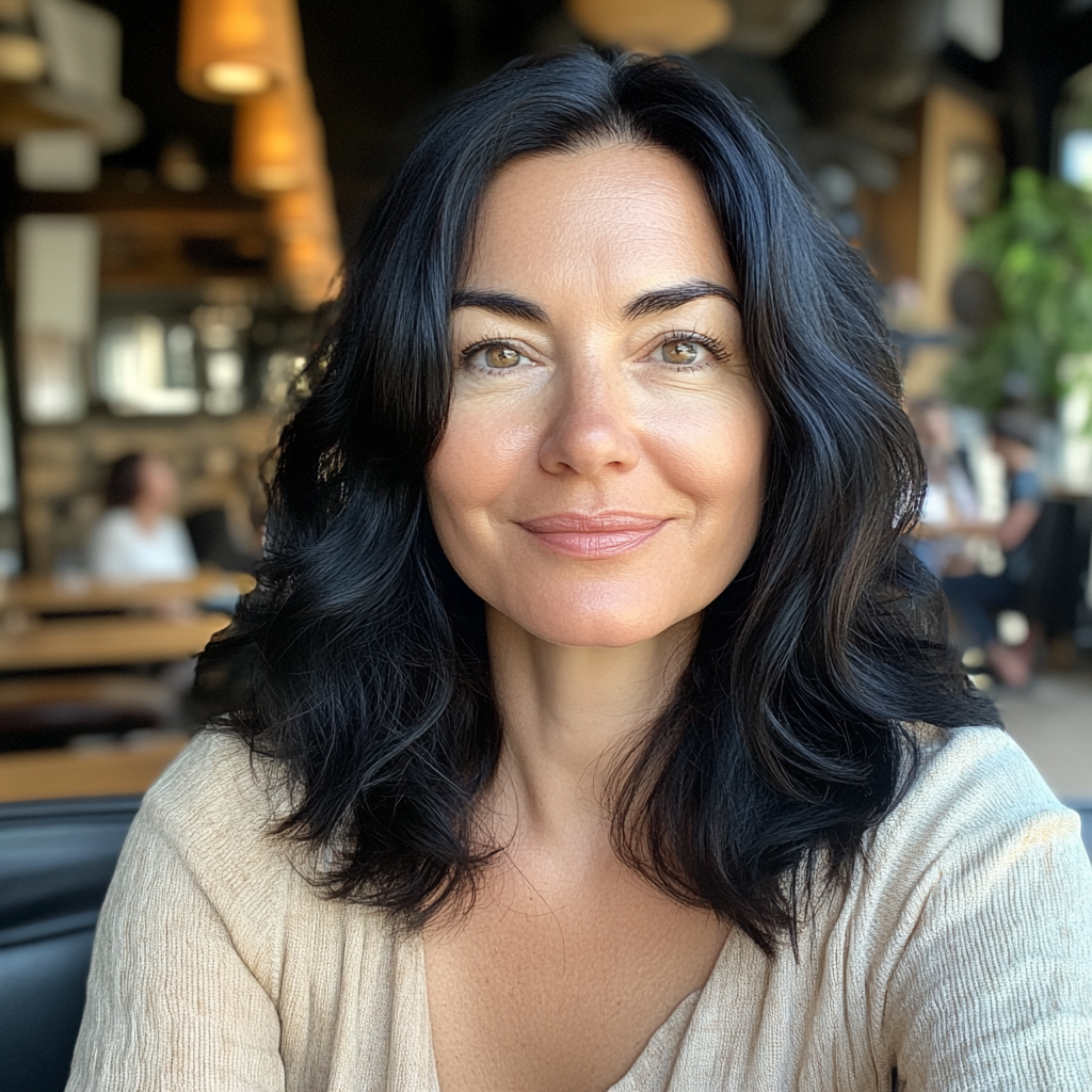 A smiling woman sitting in a coffee shop | Source: Midjourney