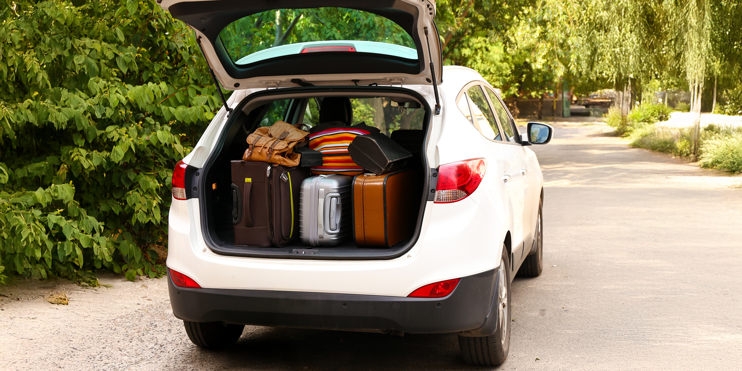 Suitcases packed into a car trunk | Source: Shutterstock