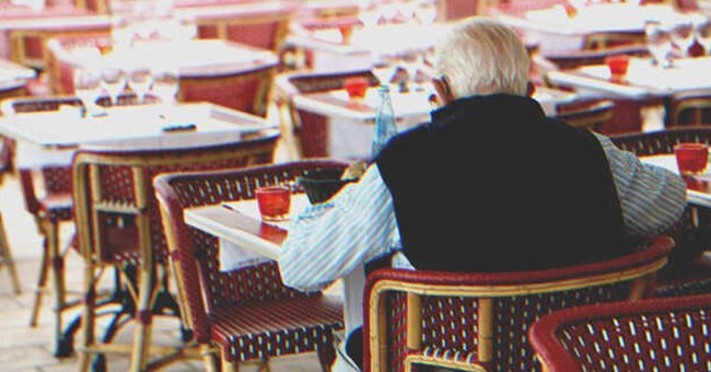 An old man sitting at a table | Source: Shutterstock