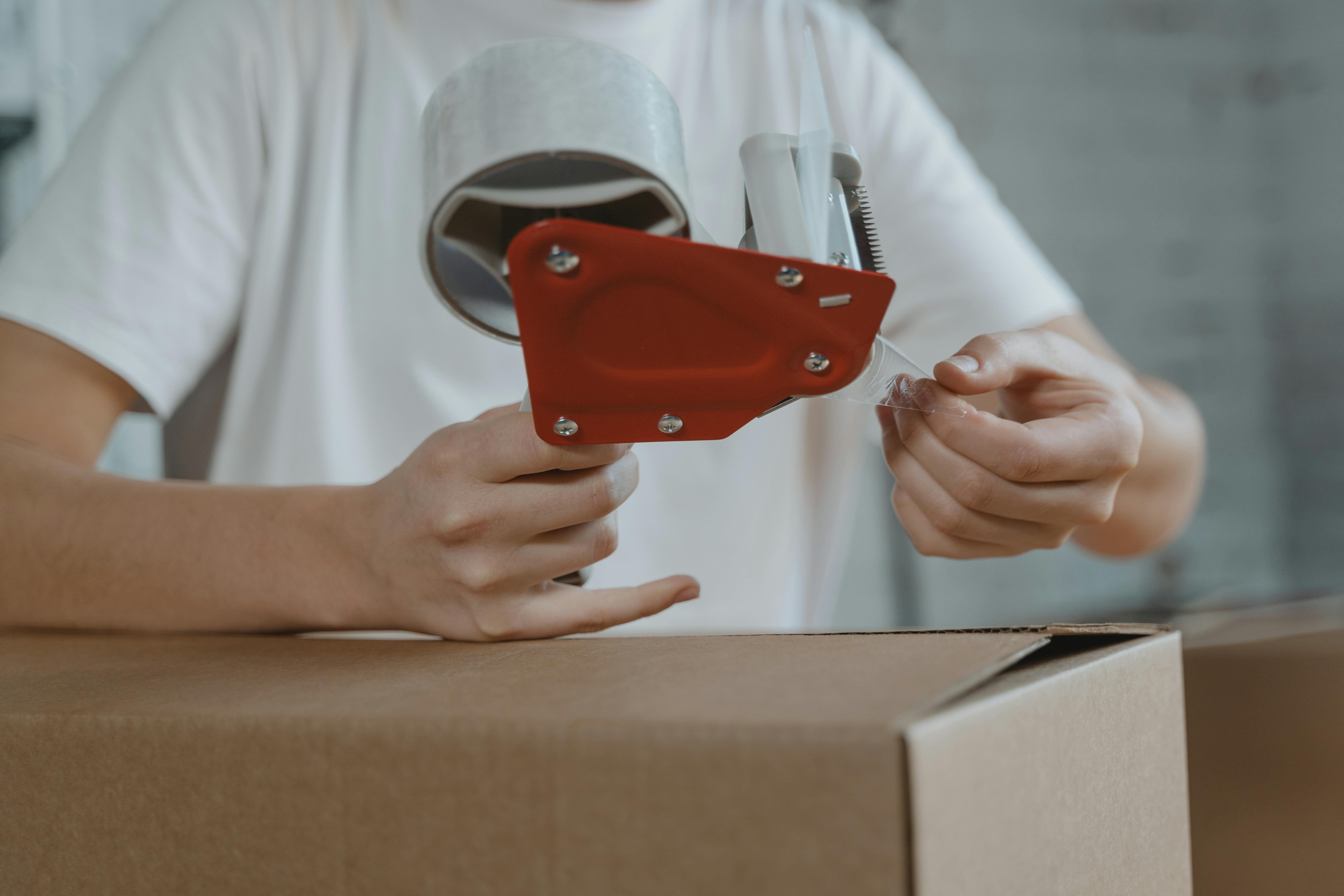 A man sealing a box | Source: Pexels