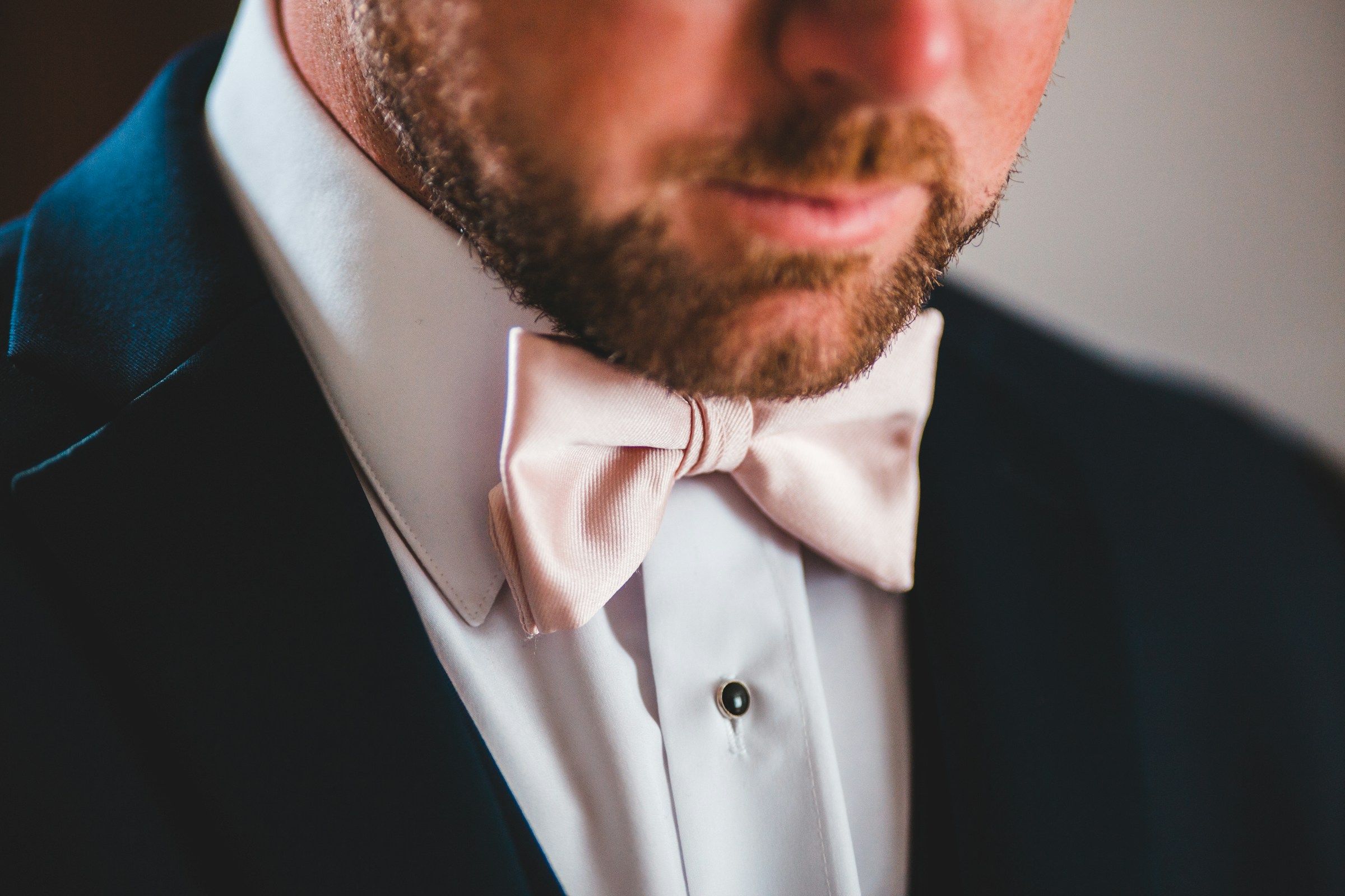 A man in a tuxedo with a pink bow tie | Source: Unsplash