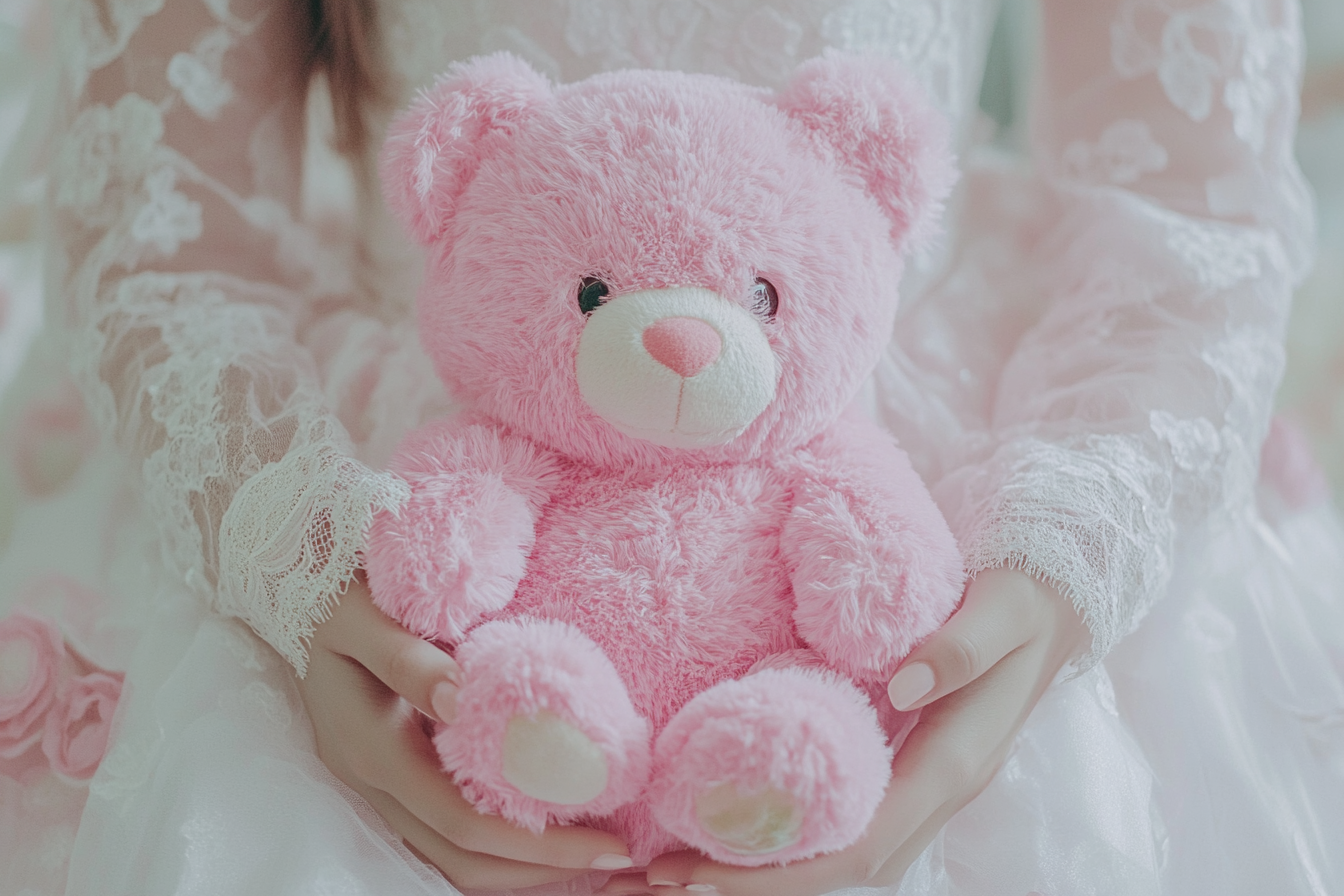 A woman holding a pink teddy bear | Source: Midjourney