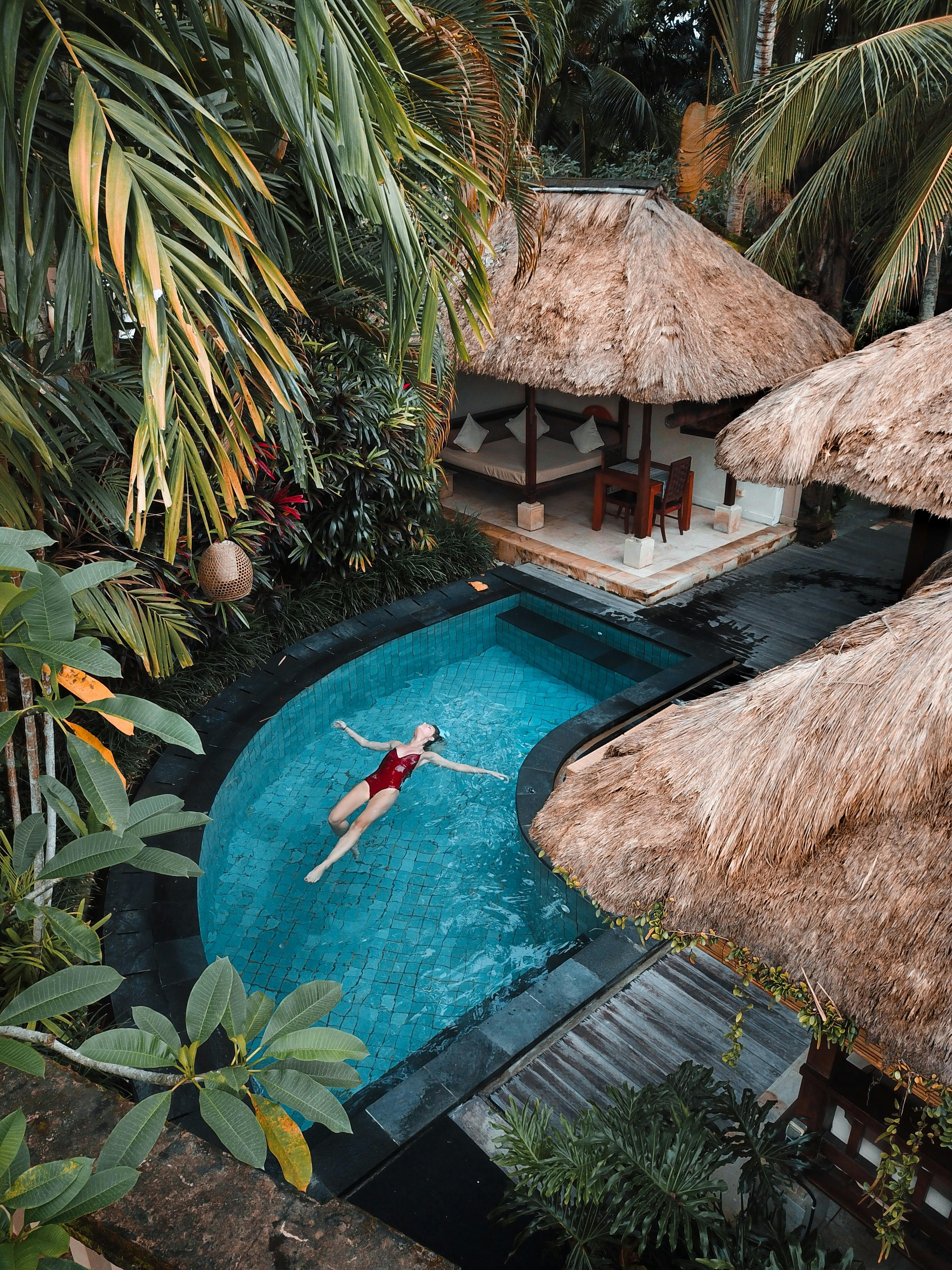 A figure floating leisurely in a tropical resort pool | Source: Pexels