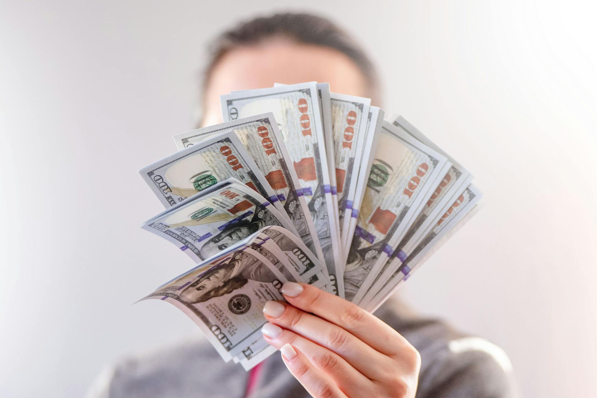 A woman holding dollar bills | Source: Pexels