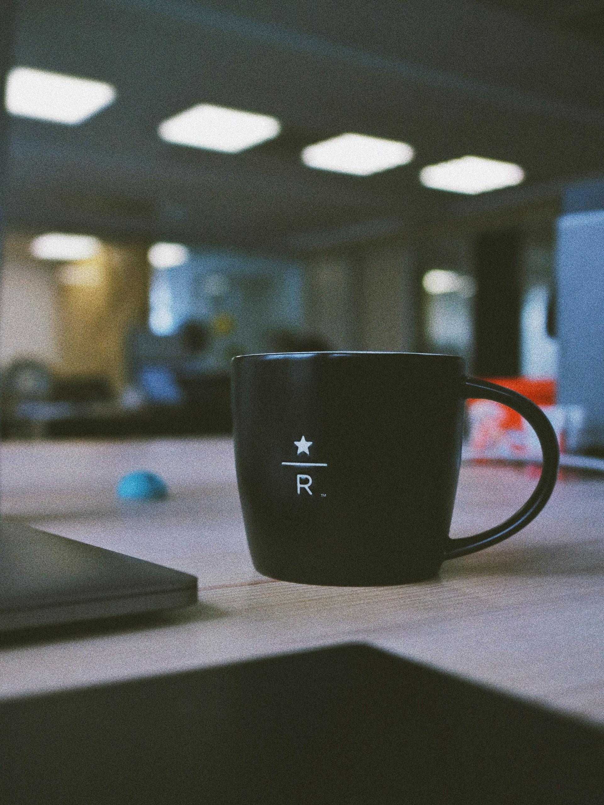 A black coffee mug on an office desk | Source: Unsplash