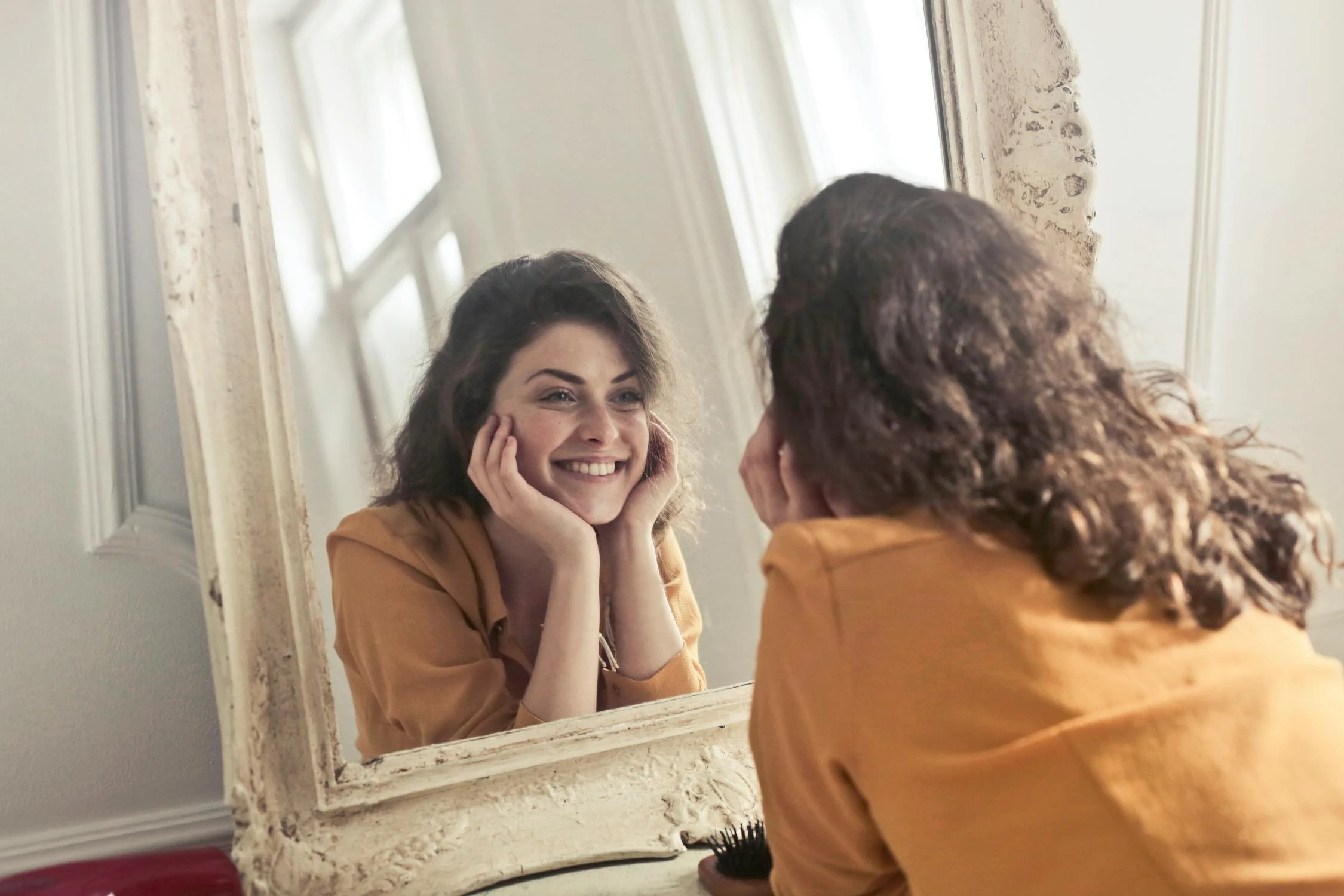 Une femme heureuse se regardant dans le miroir | Source : Pexels