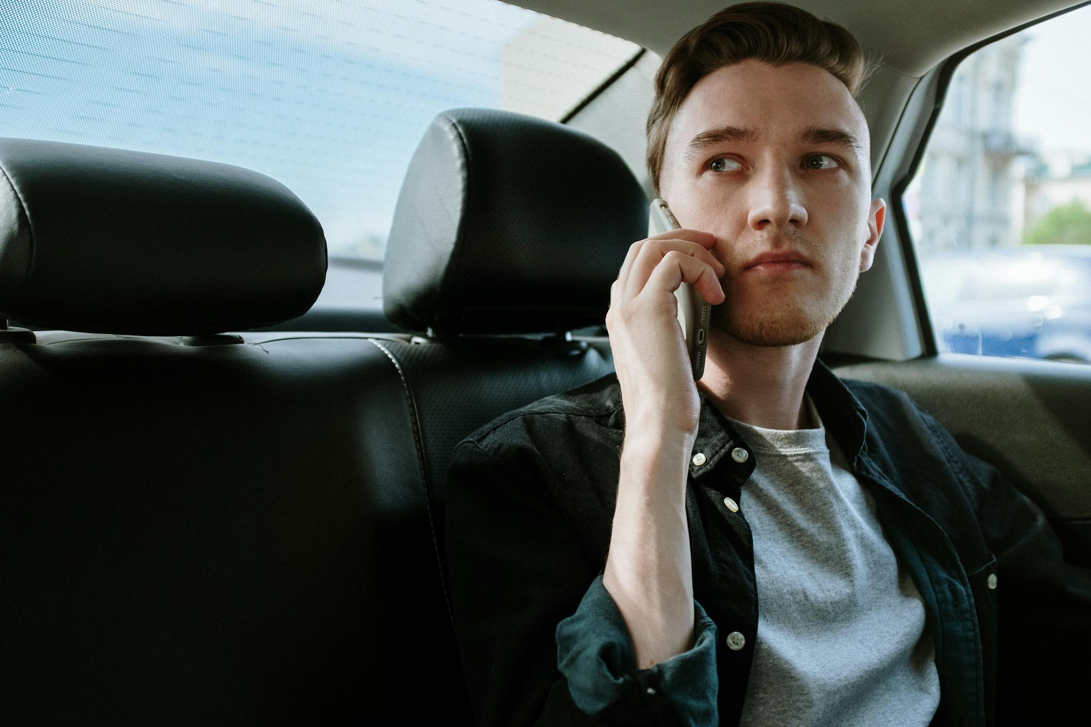 Um homem sério ao telefone no carro | Fonte: Pexels