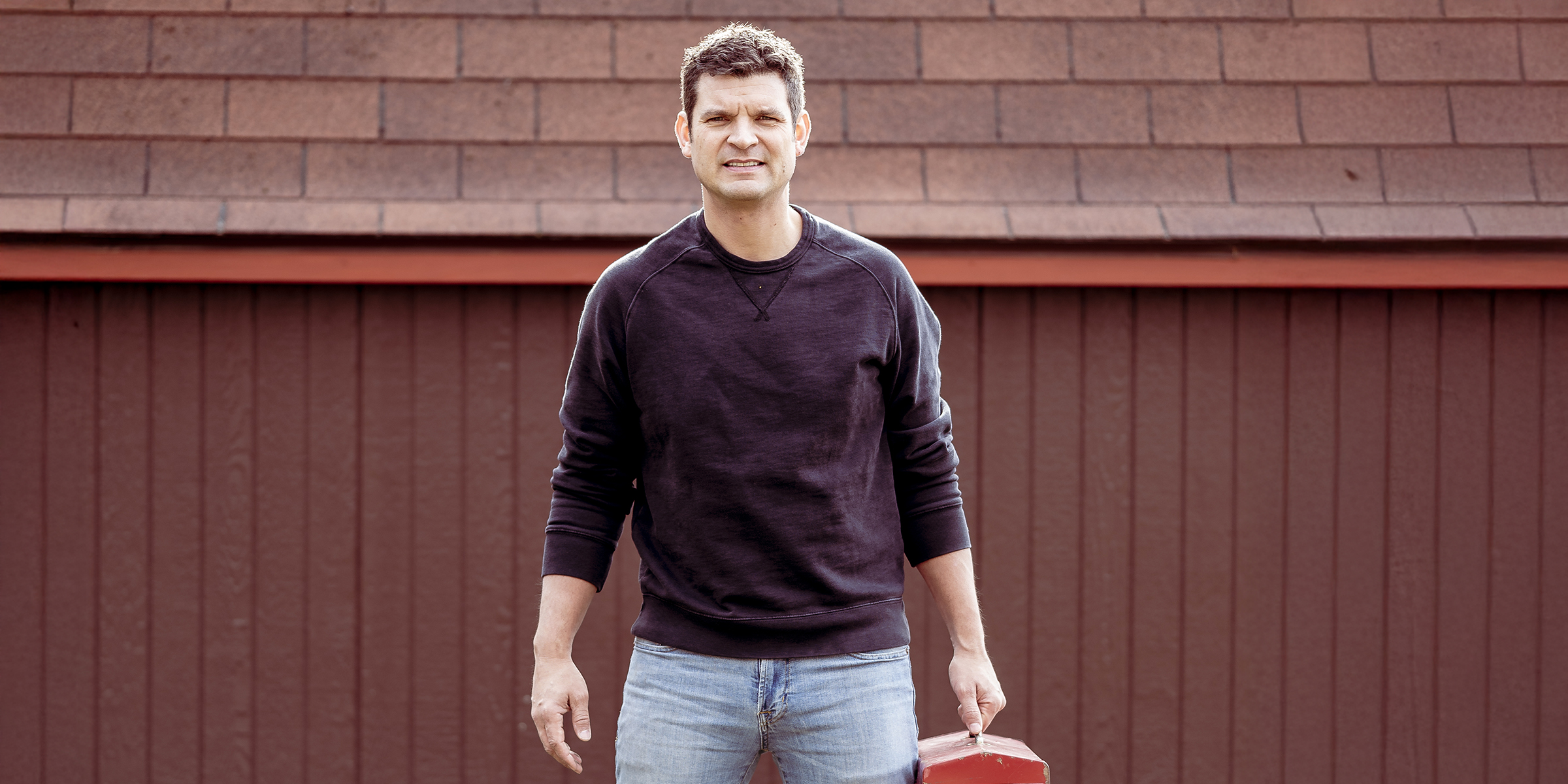 A man standing in front of a garage | Source: Shutterstock