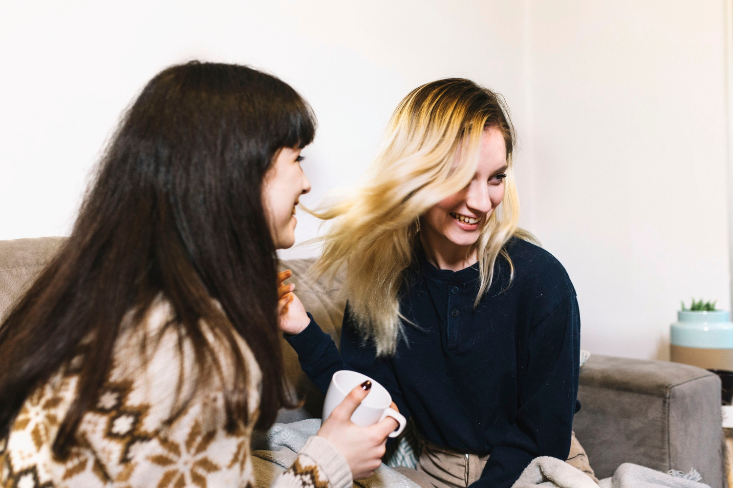 Two delighted women sitting on a couch | Source: Freepik