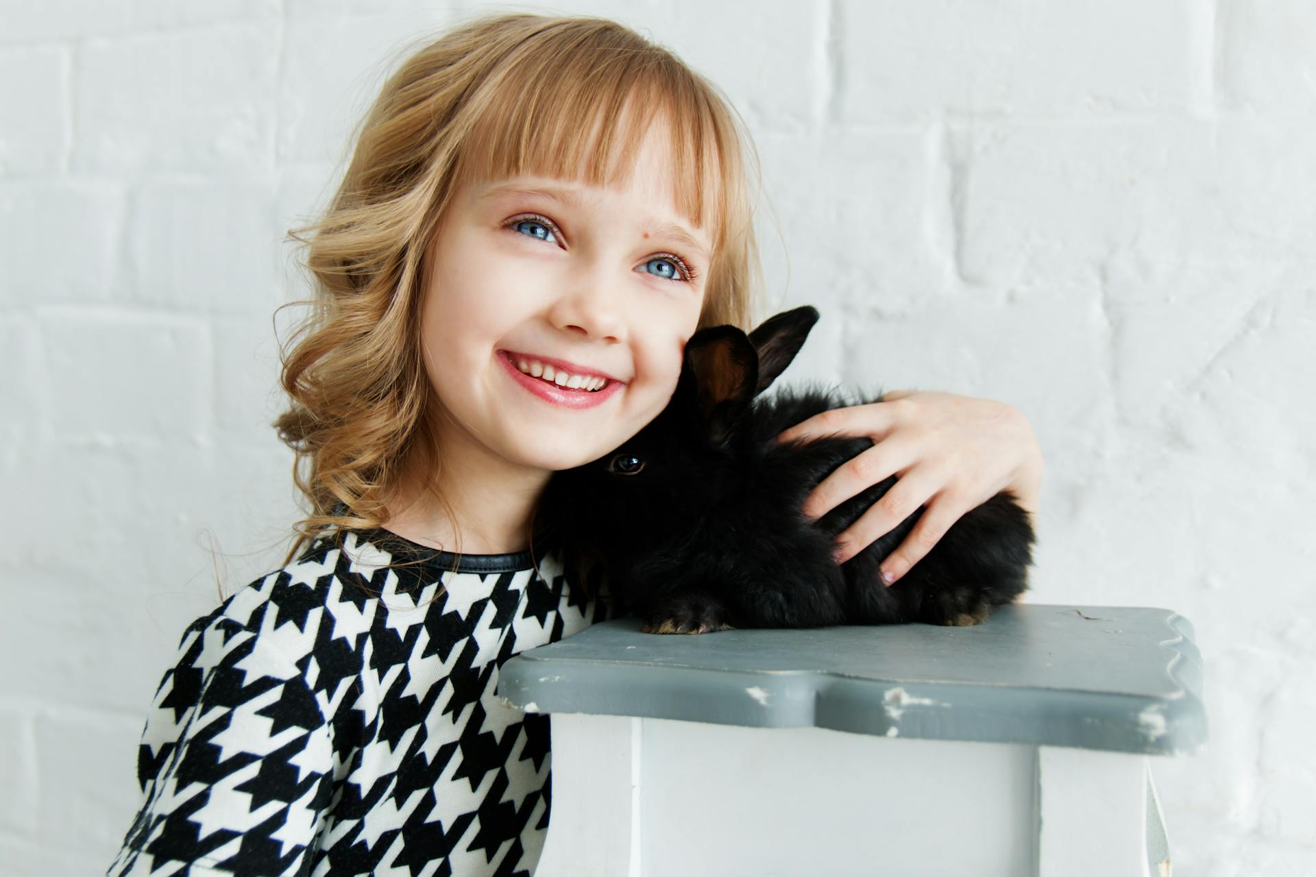 A delighted little girl holding her pet rabbit | Source: Pexels