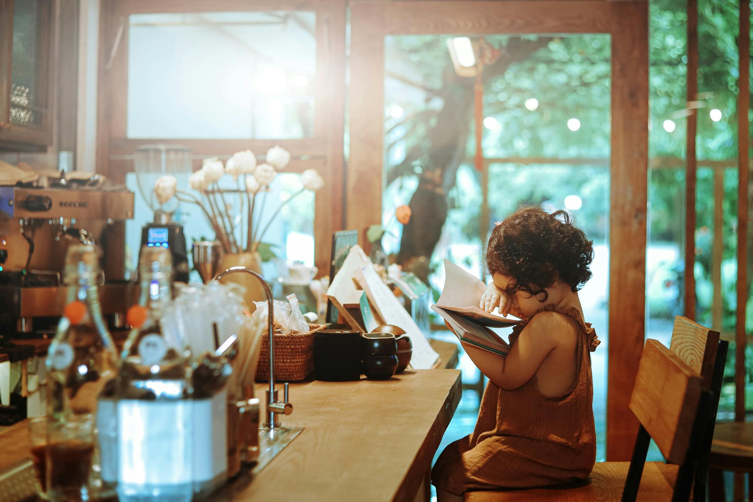 A small child sitting on a stool in a coffee shop | Source: Pexels