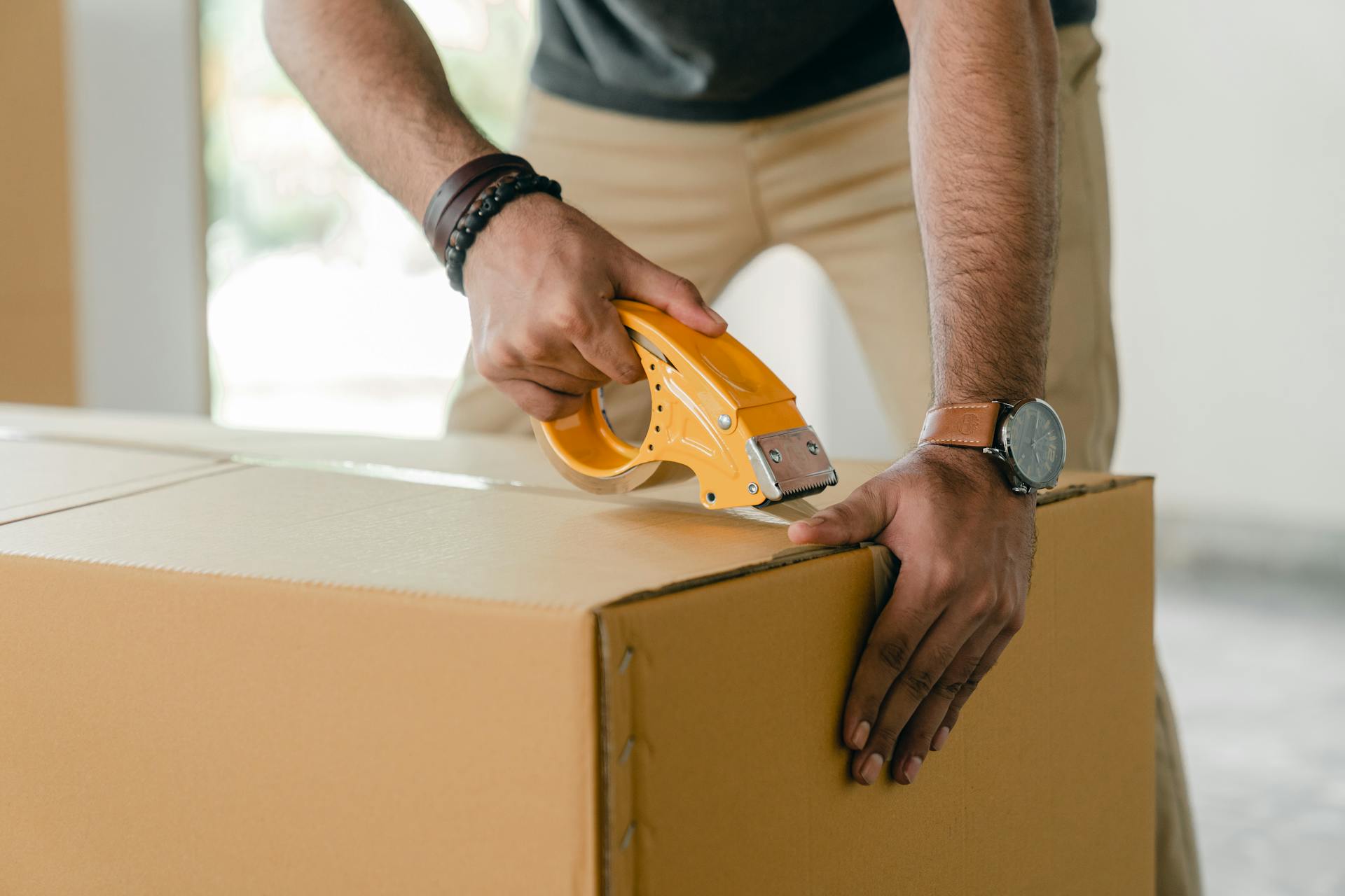A man packing clothes in a box | Source: Pexels