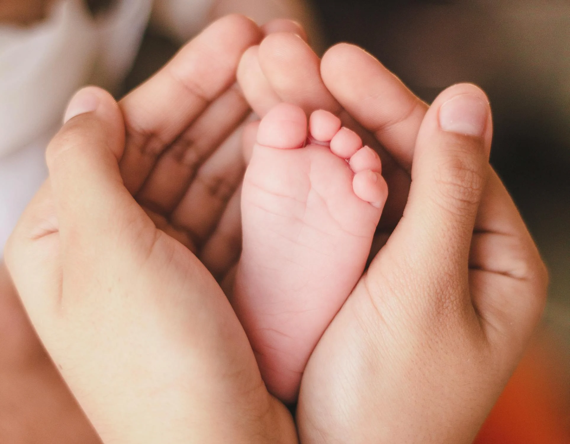 A woman holding a baby's foot | Source: Pexels