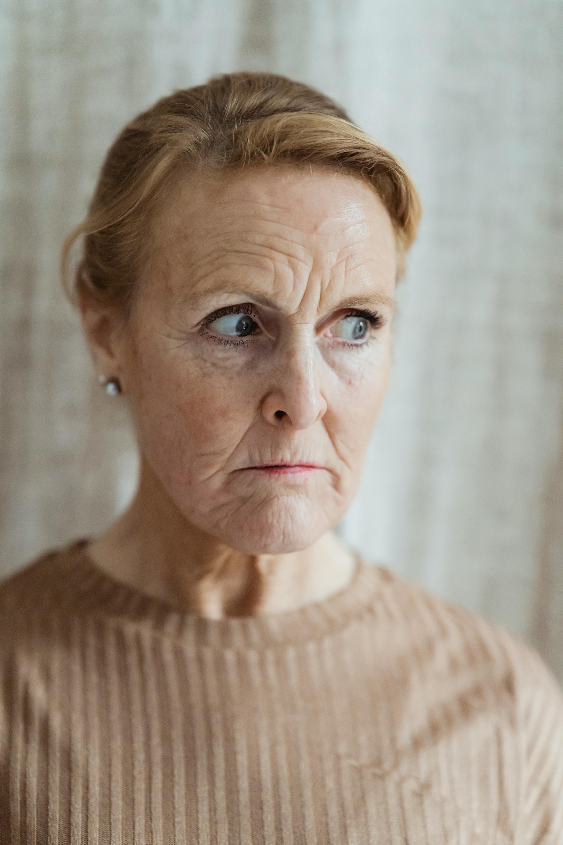 A close-up of a concerned mature woman with wrinkles and a furrowed brow | Source: Pexels