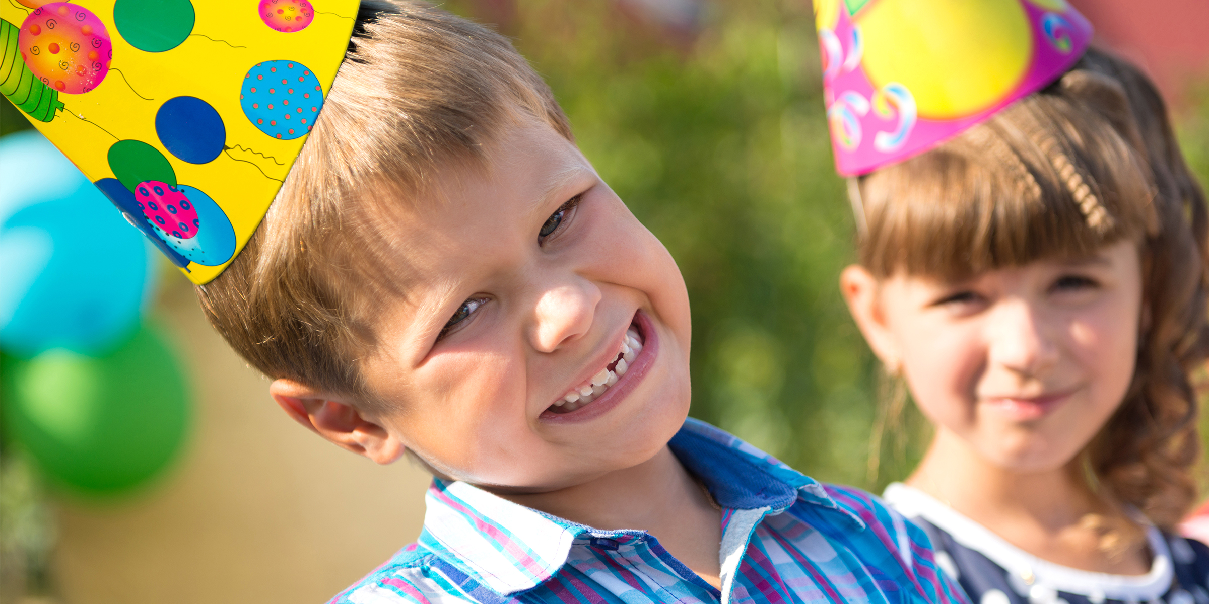 Kids enjoying a cheerful moment in party hats and sunshine | Source: Shutterstock