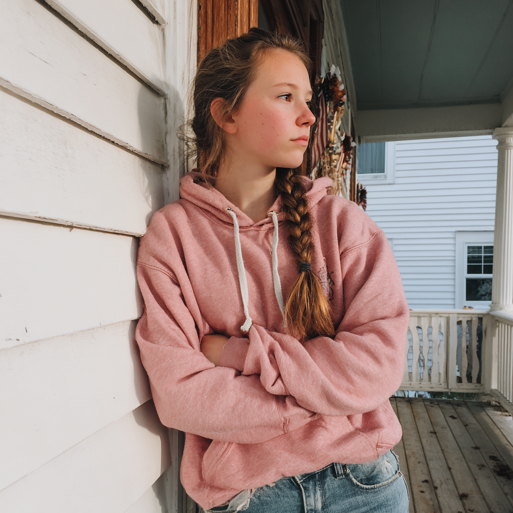 A teenage girl standing on a porch | Source: Midjourney