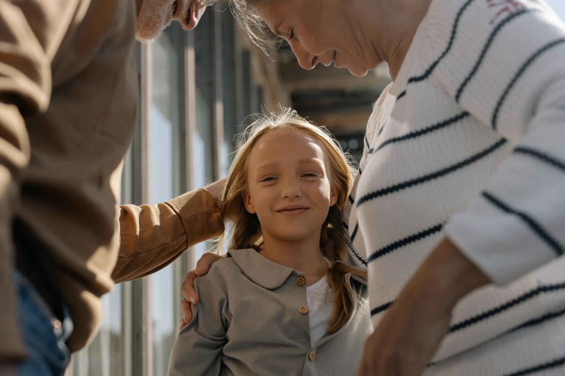 A happy young girl with her grandparents | Source: Pexels