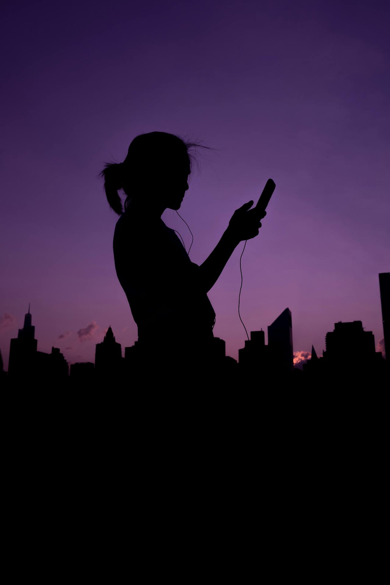 Silhouette of a woman holding her phone | Source: Pexels