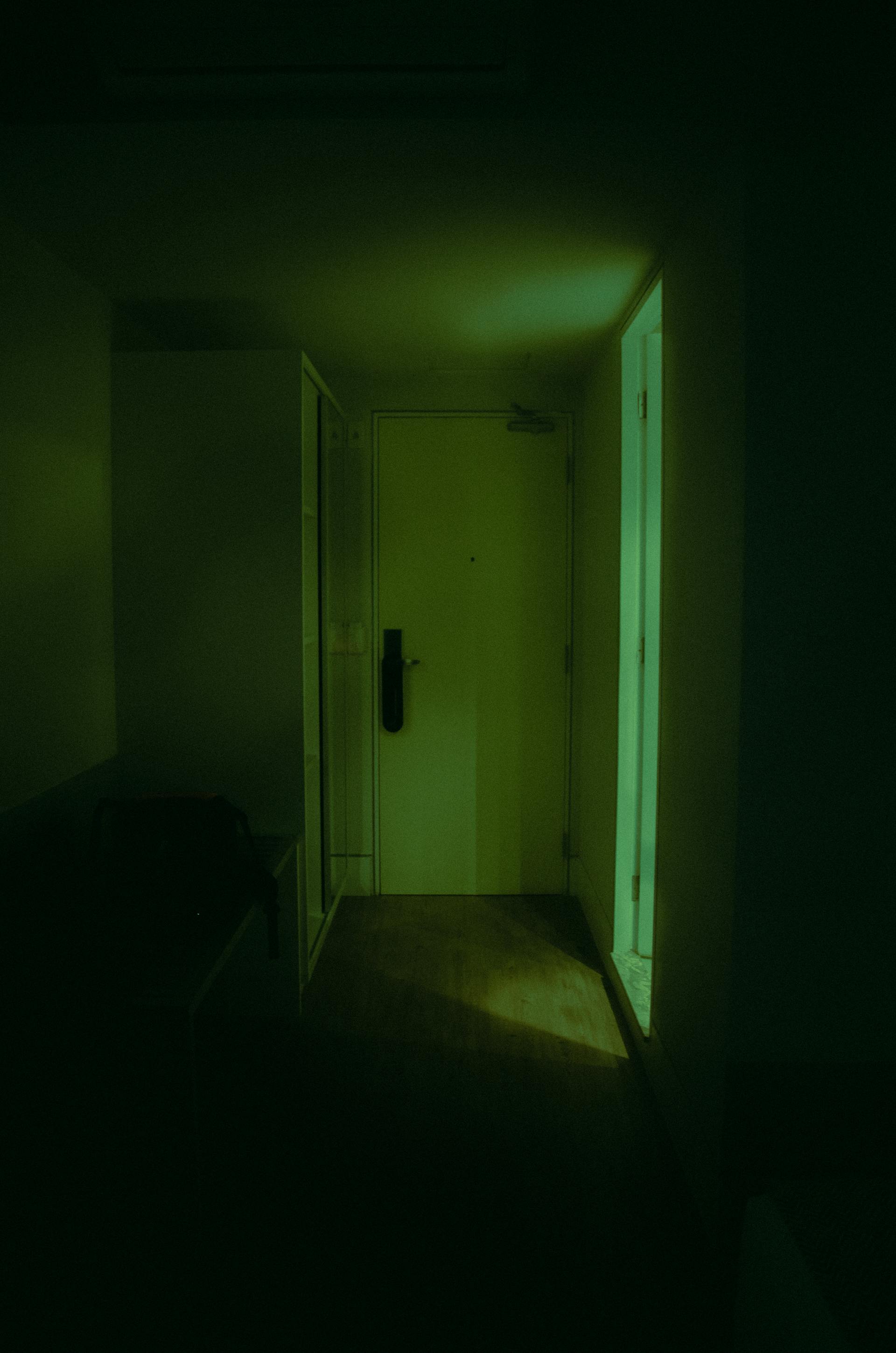A closed door at the end of a dim hallway | Source: Pexels