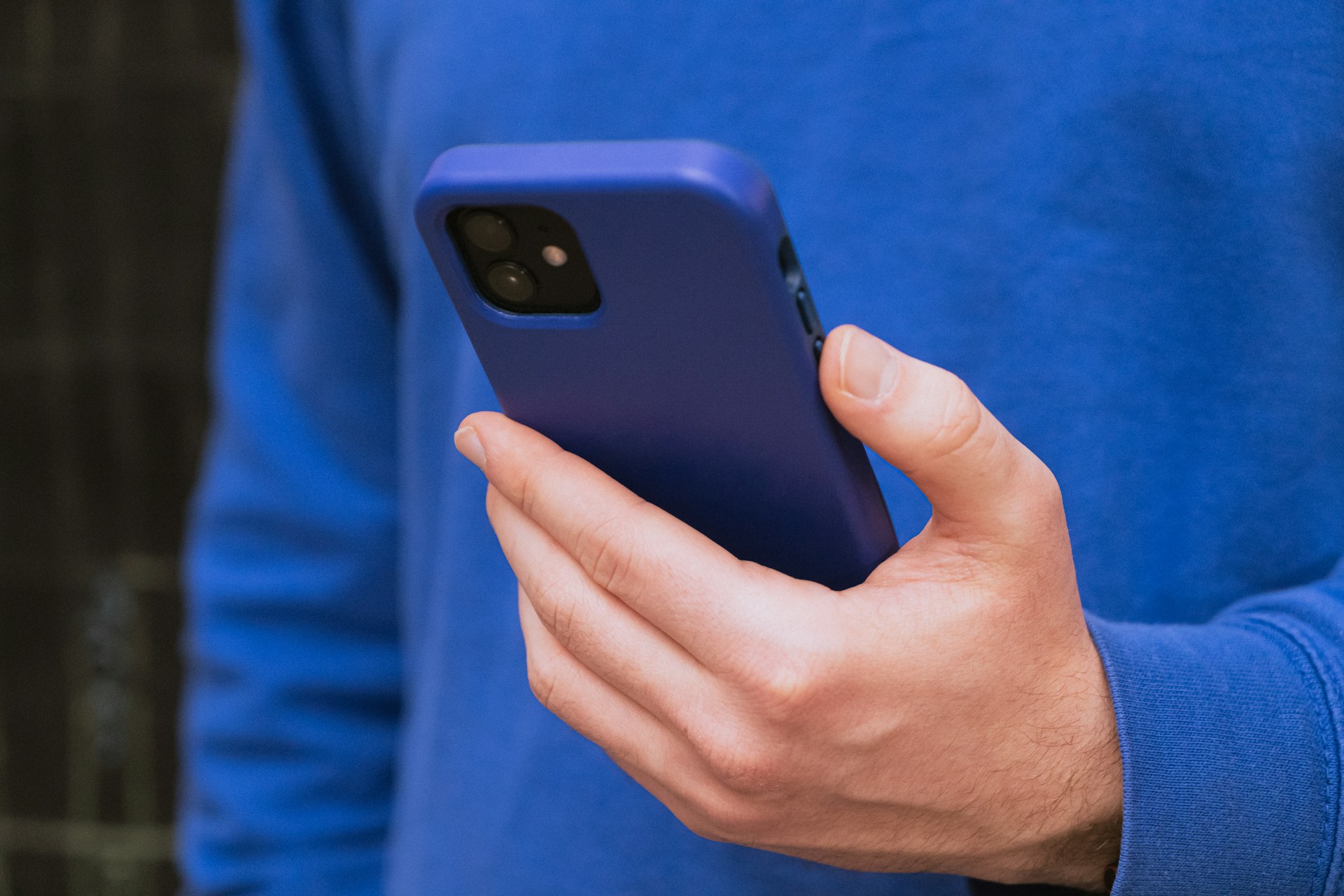 Cropped shot of a man holding his phone | Source: Unsplash