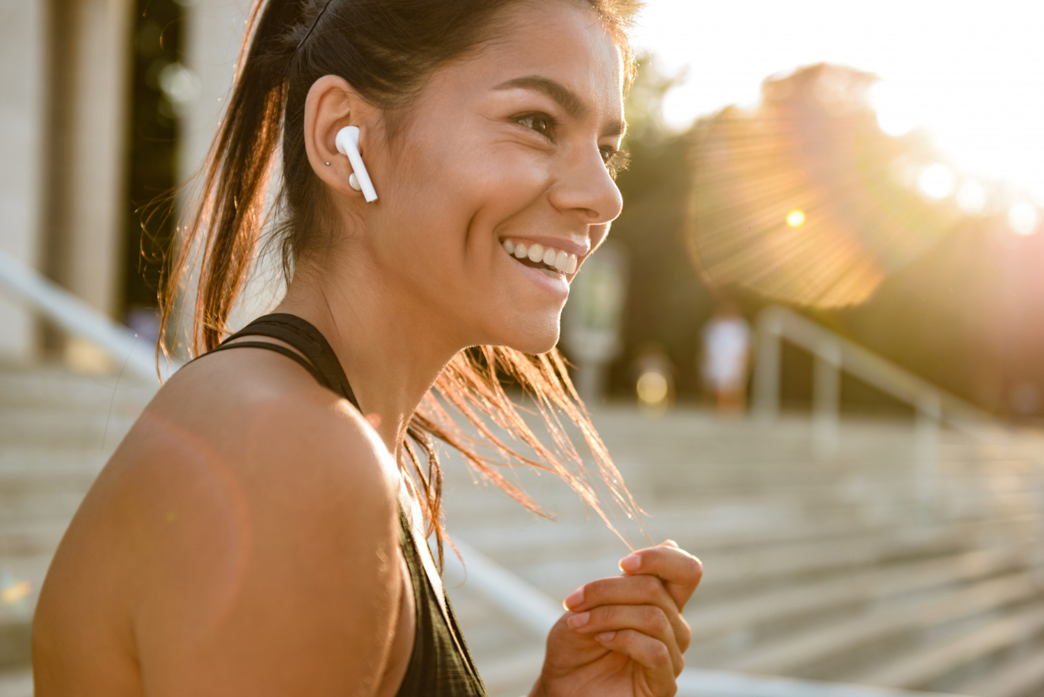 A happy woman wearing an earpiece | Source: Freepik