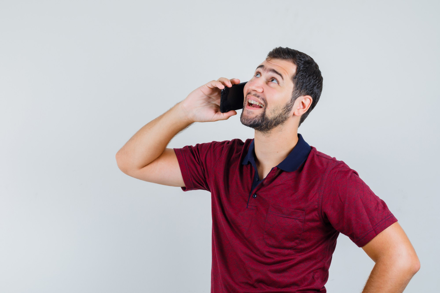 A cheerful man talking on the phone | Source: Freepik