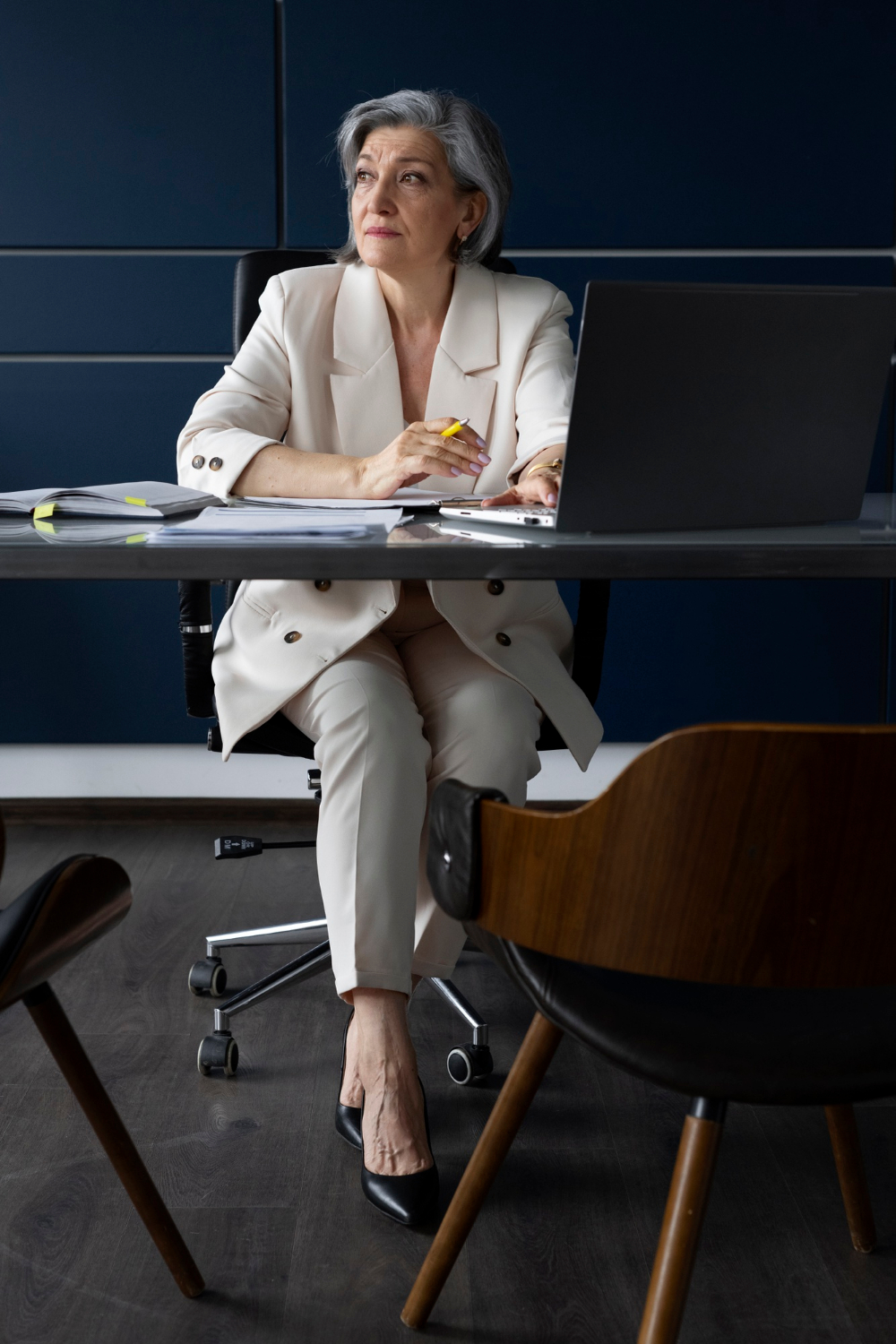 A senior woman seated in her office | Source: Freepik