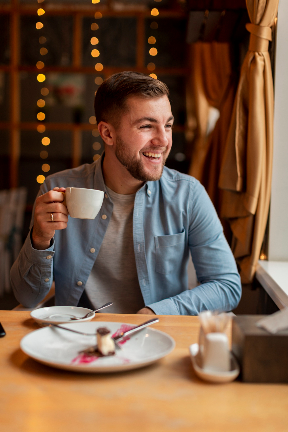A man holding a cup and laughing | Source: Freepik
