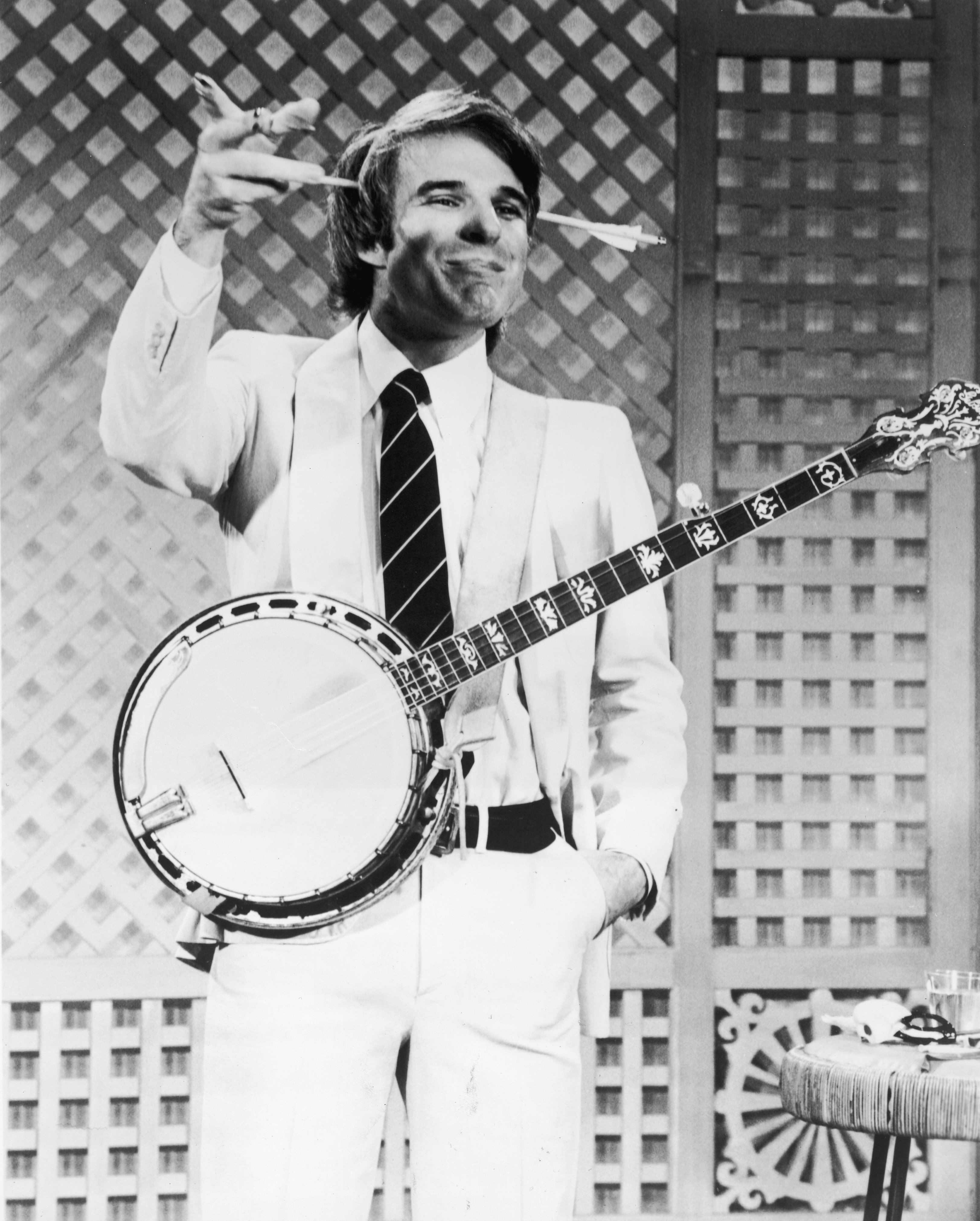 Steve Martin gestures while wearing a gag arrow on his head and a banjo during a television appearance, 1978 | Source: Getty Images