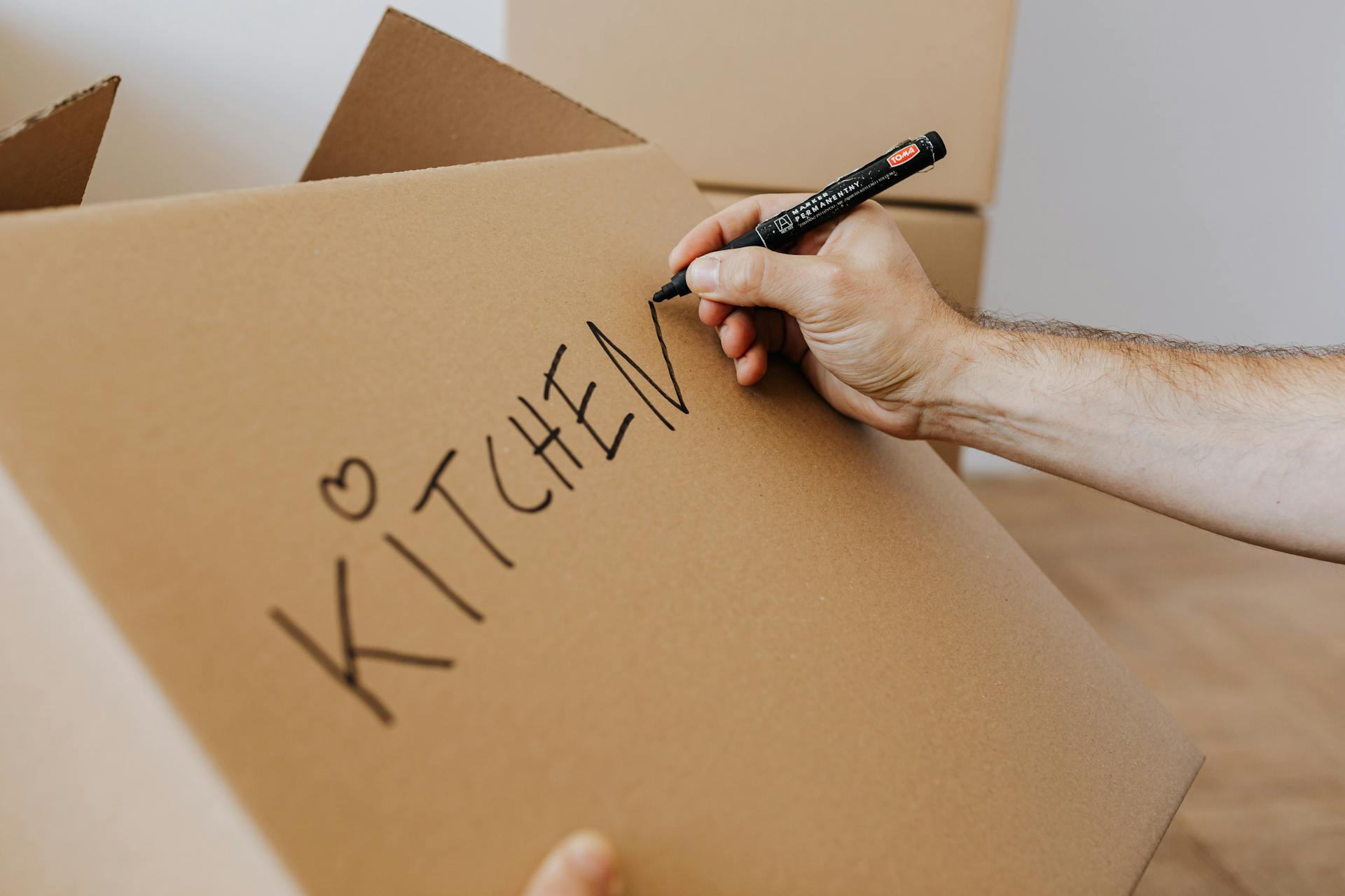 Close-up shot of a man labeling a box | Source: Pexels