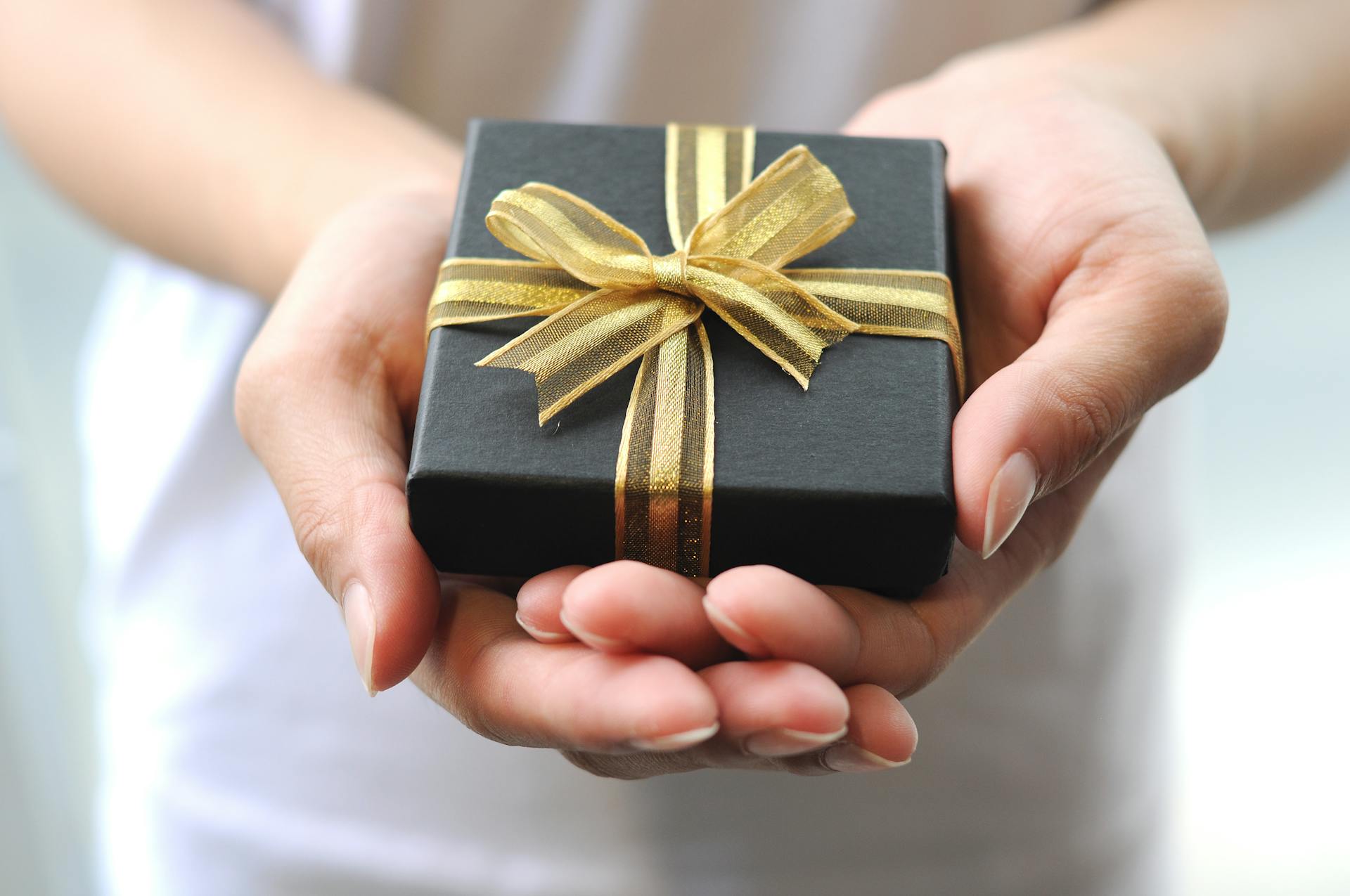 A woman holding a gift box | Source: Pexels