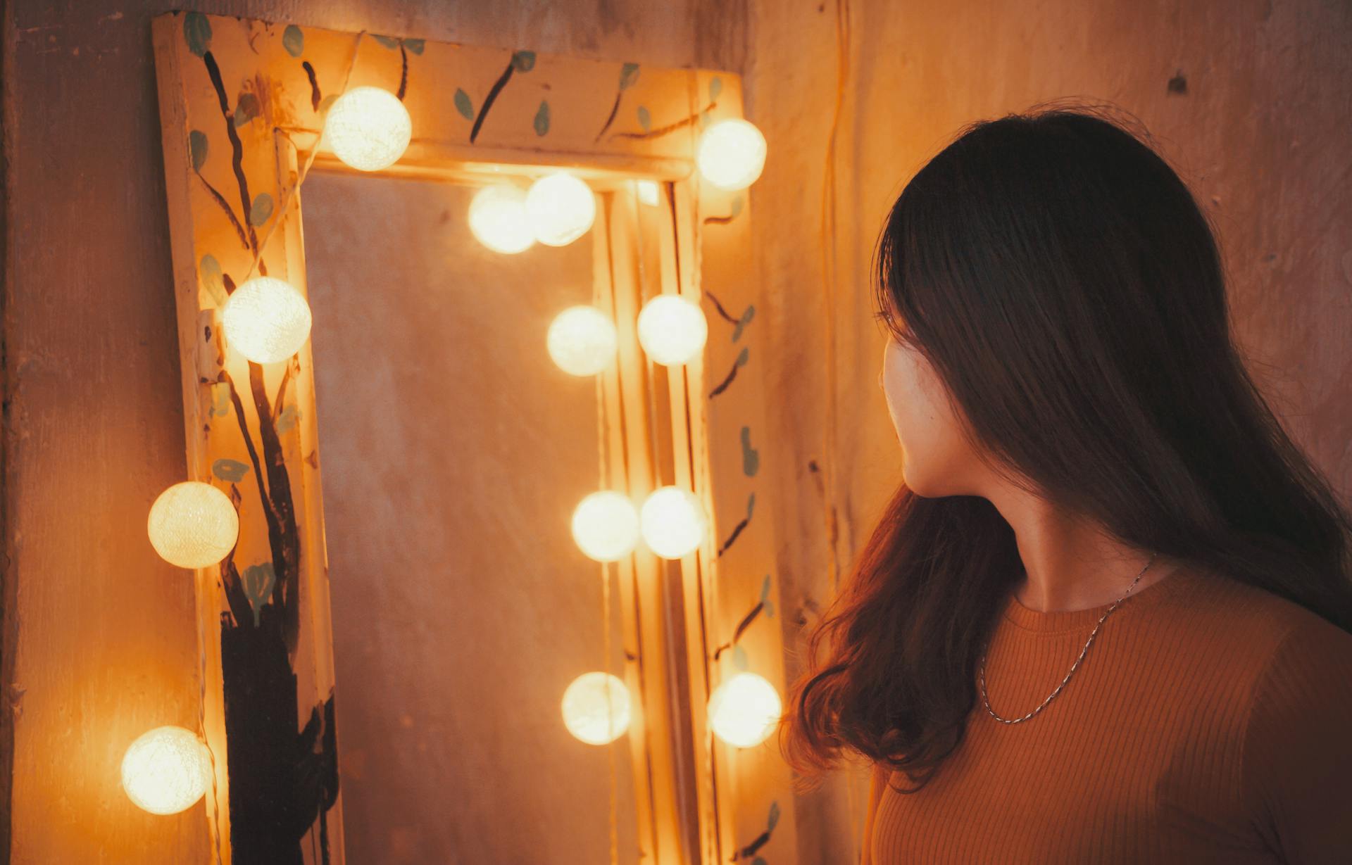 A woman glancing at herself in a mirror | Source: Pexels