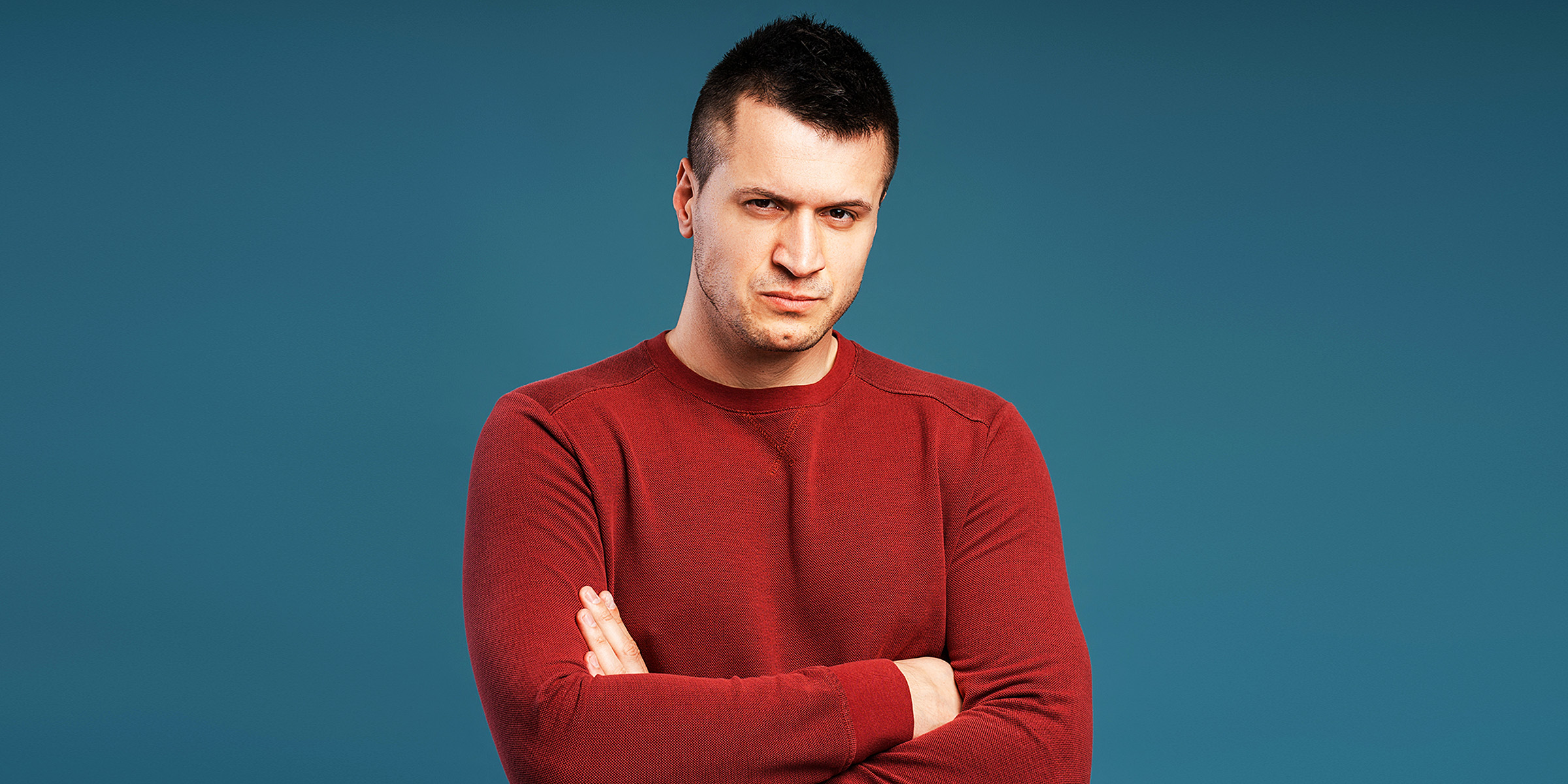 A man standing with folded arms | Source: Shutterstock