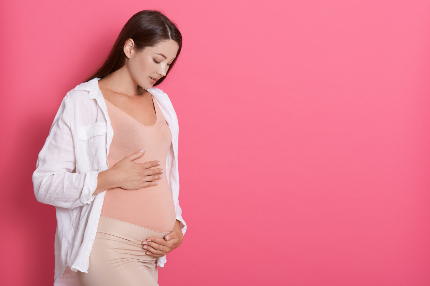 A pregnant woman looking at her baby bump | Source: Freepik
