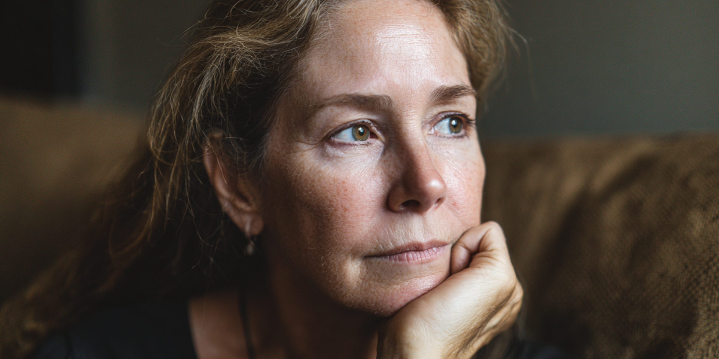 A woman sitting and staring with a distant, pained expression | Souce: The Celebritist