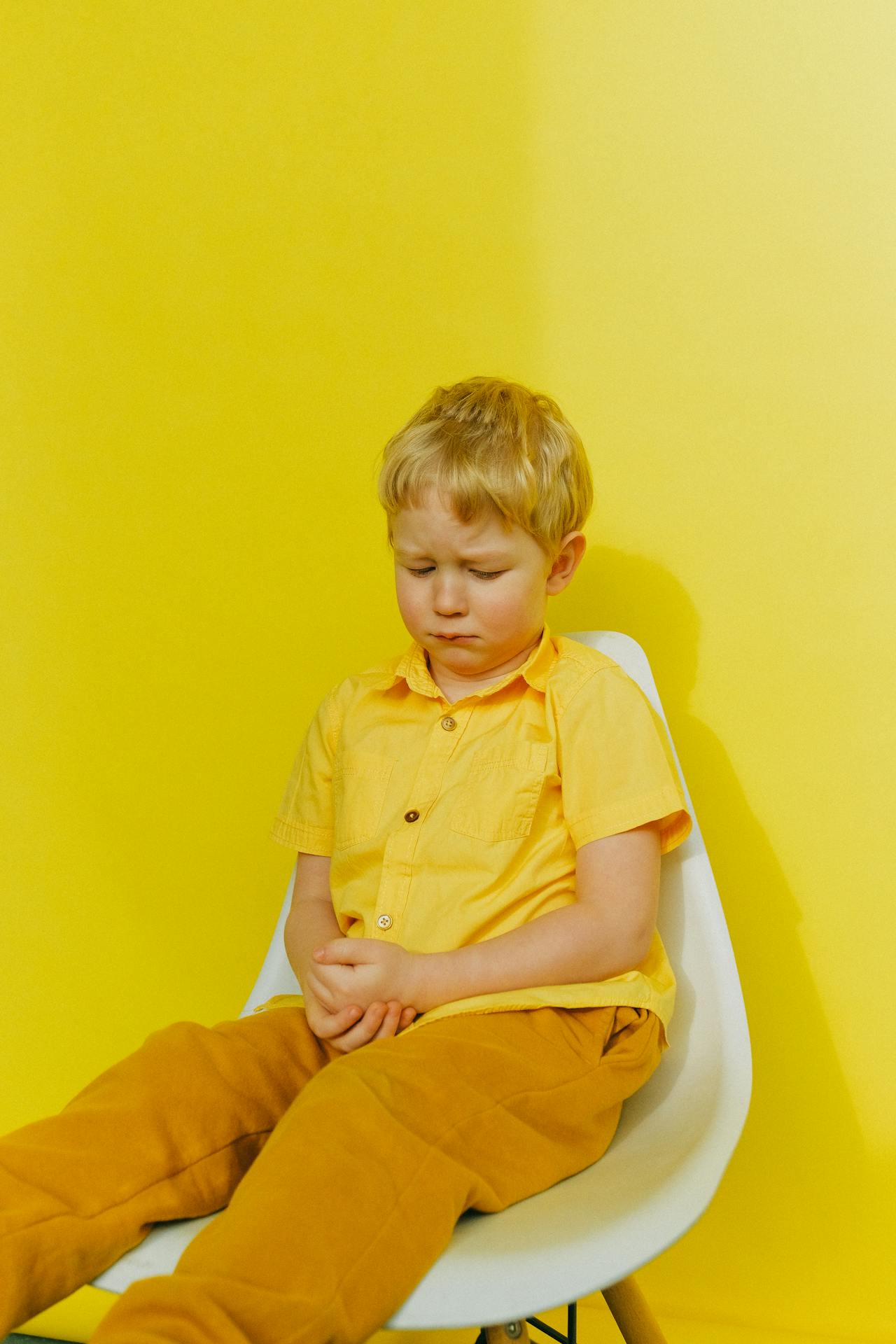 An upset boy sitting on a chair | Source: Pexels