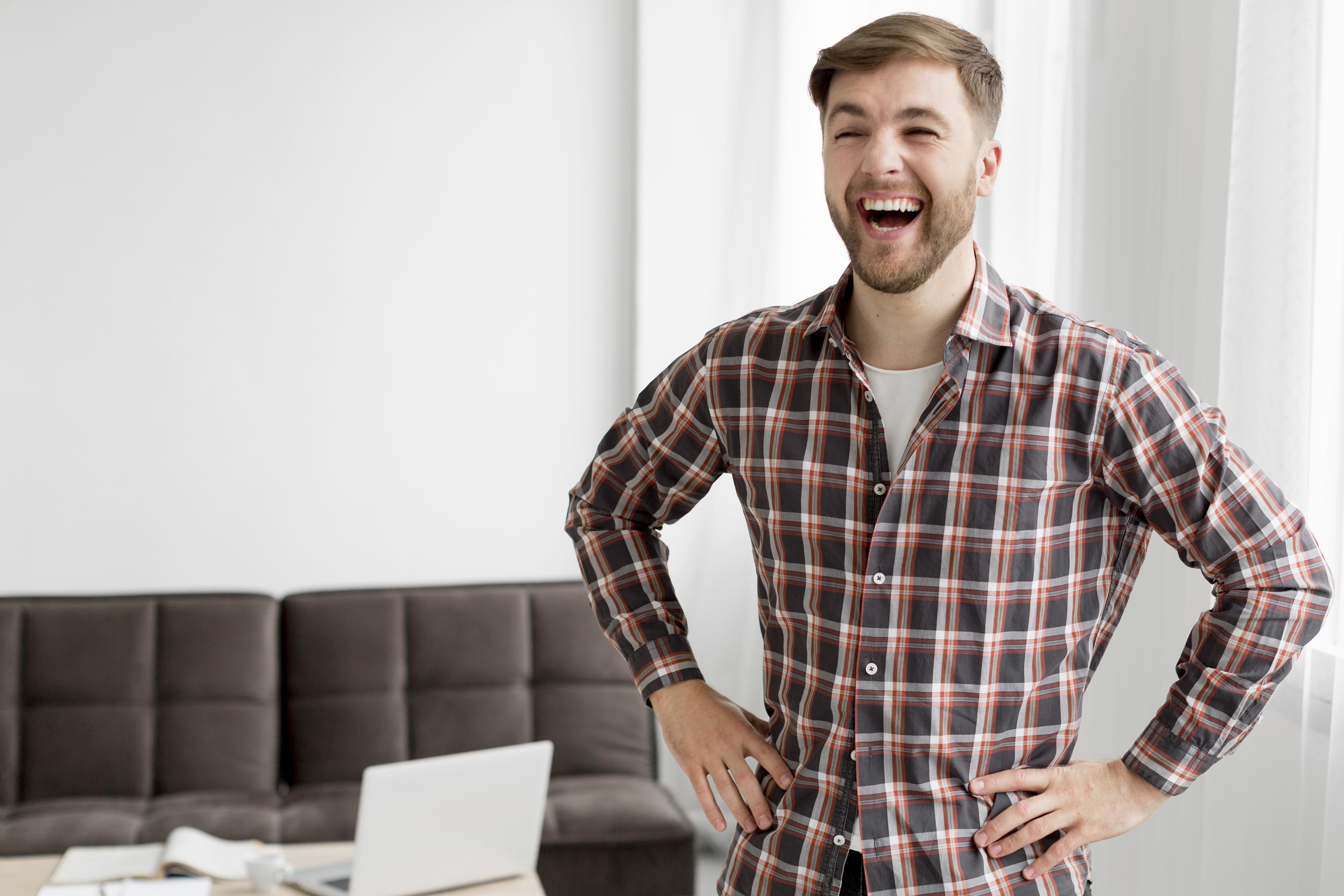 A man laughing with his hands on his hip | Source: Freepik