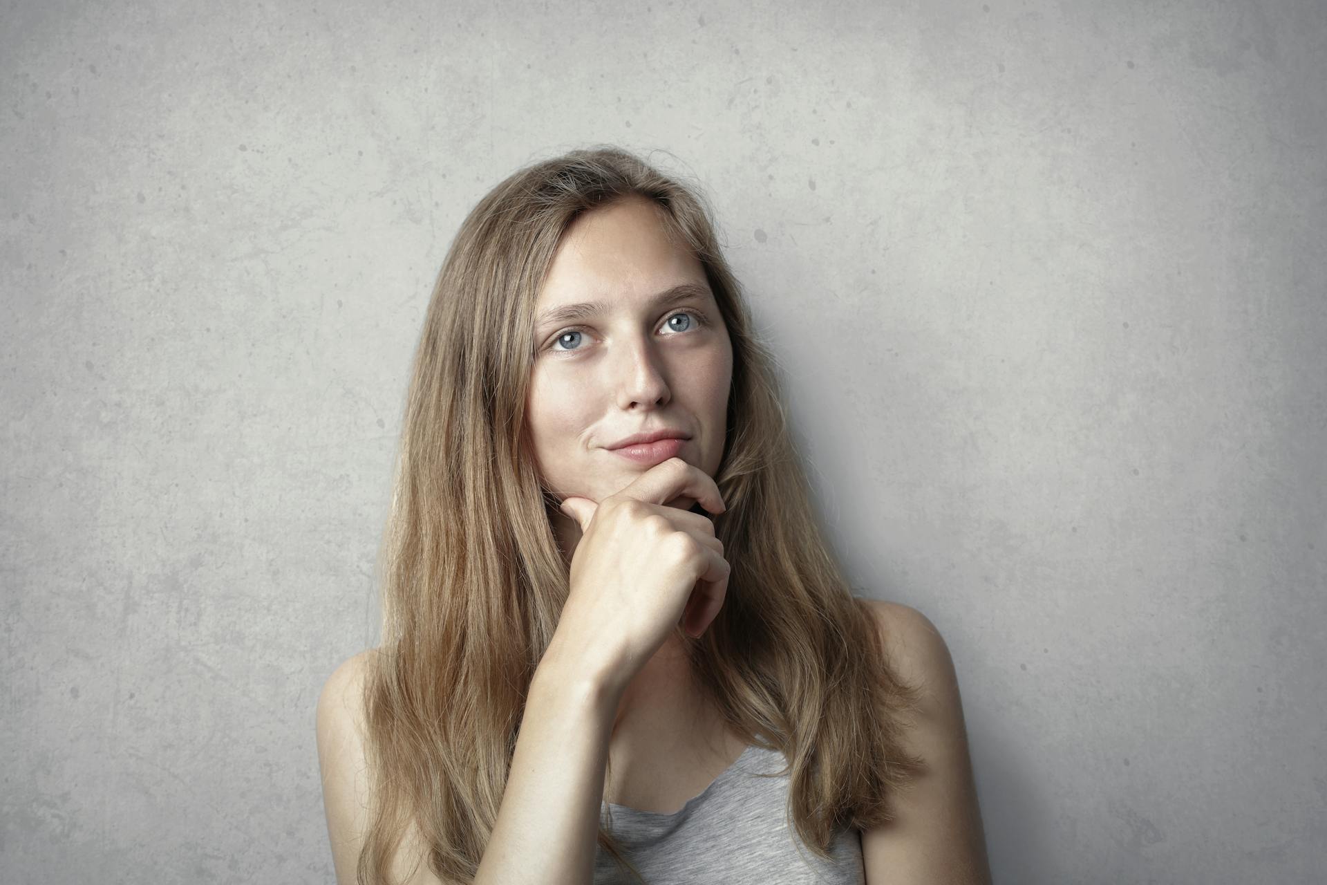 A woman smirking thoughtfully | Source: Pexels
