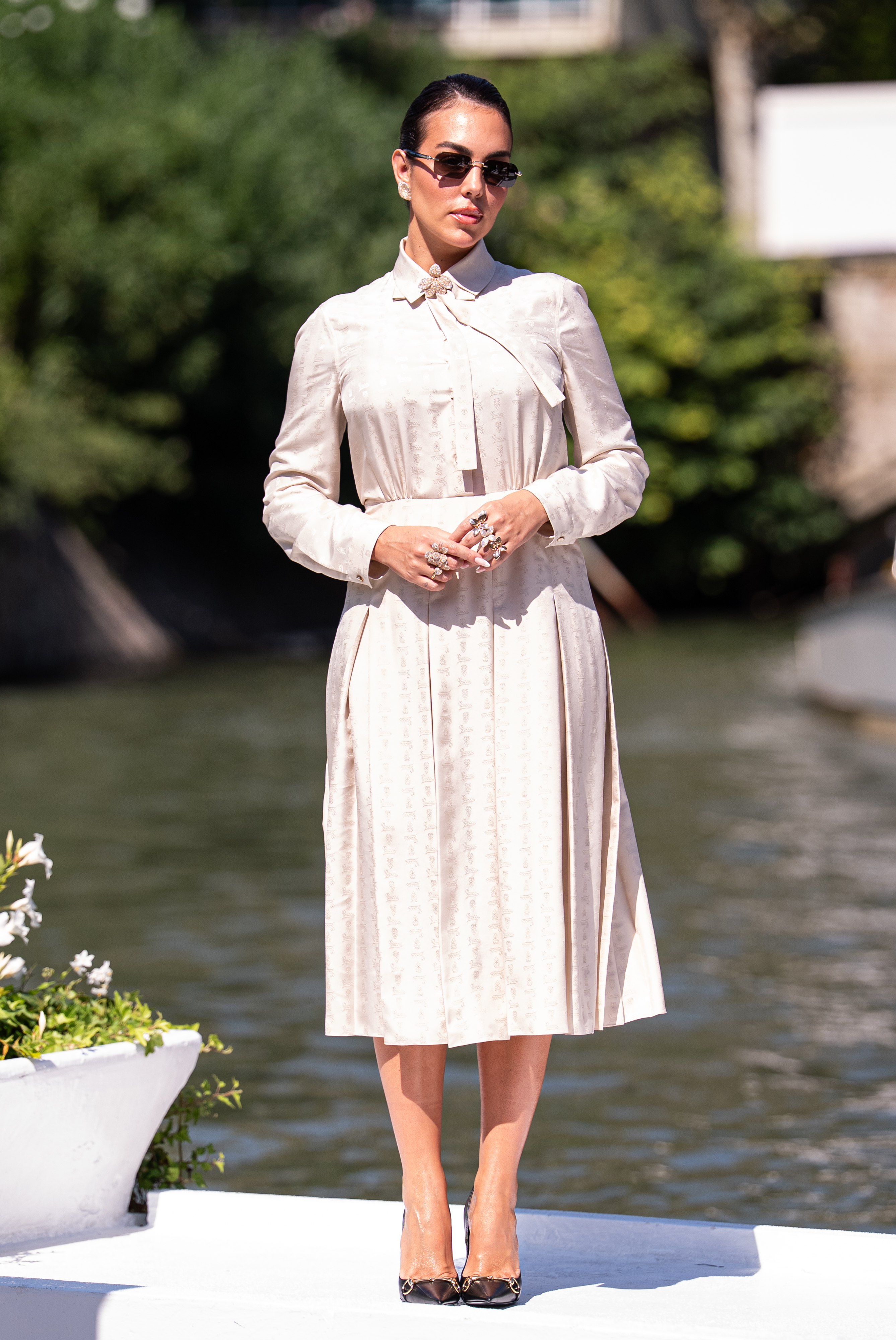 Georgina Rodríguez is seen at the Hotel Excelsior Venice Lido pier during the 83rd Venice International Film Festival on September 4, 2026, wearing a light beige Gucci dress with a pussy-bow neckline, long sleeves, and pleated midi skirt. | Source: Getty Images