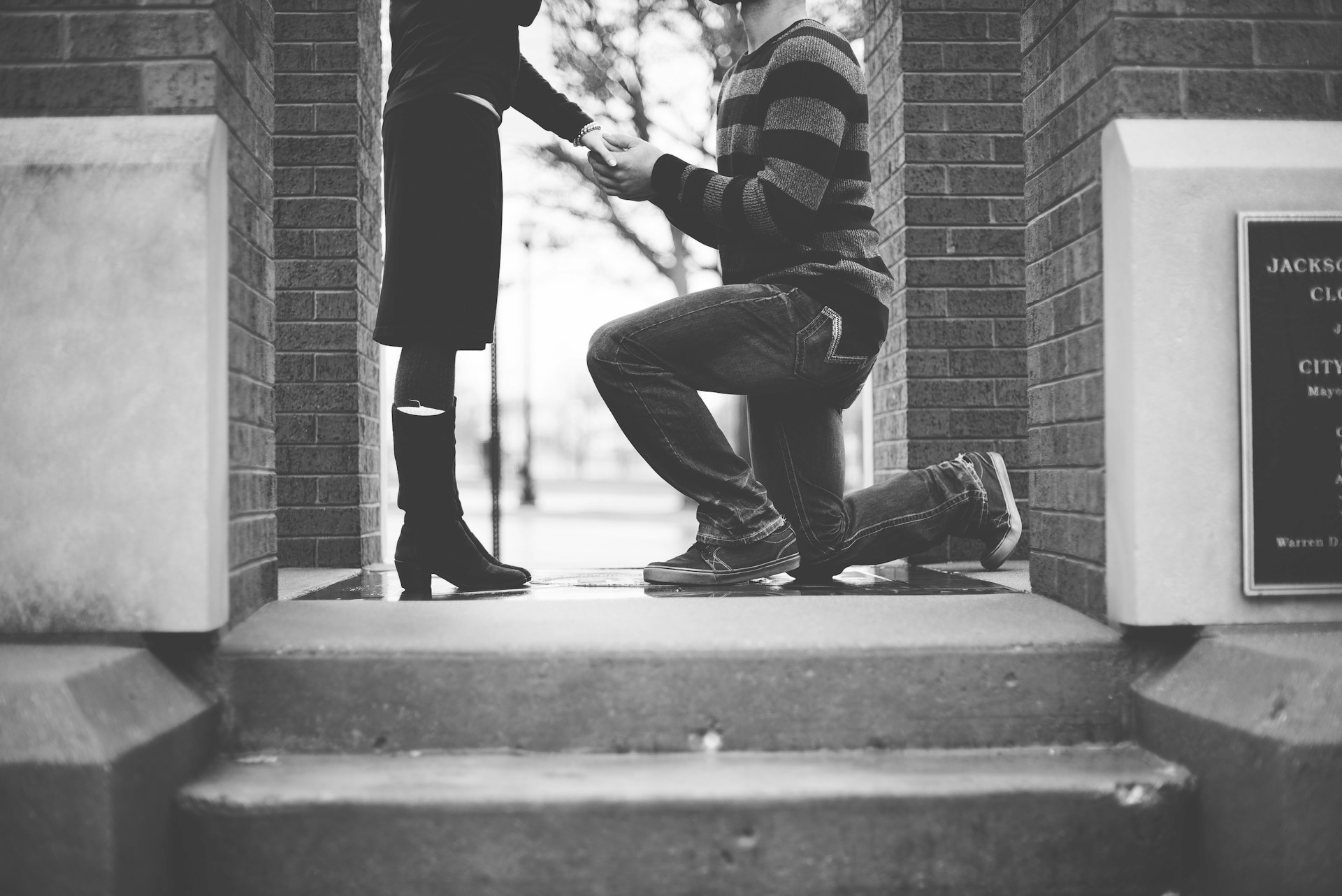 Photo en niveaux de gris d'un homme demandant sa petite amie en mariage | Source : Unsplash