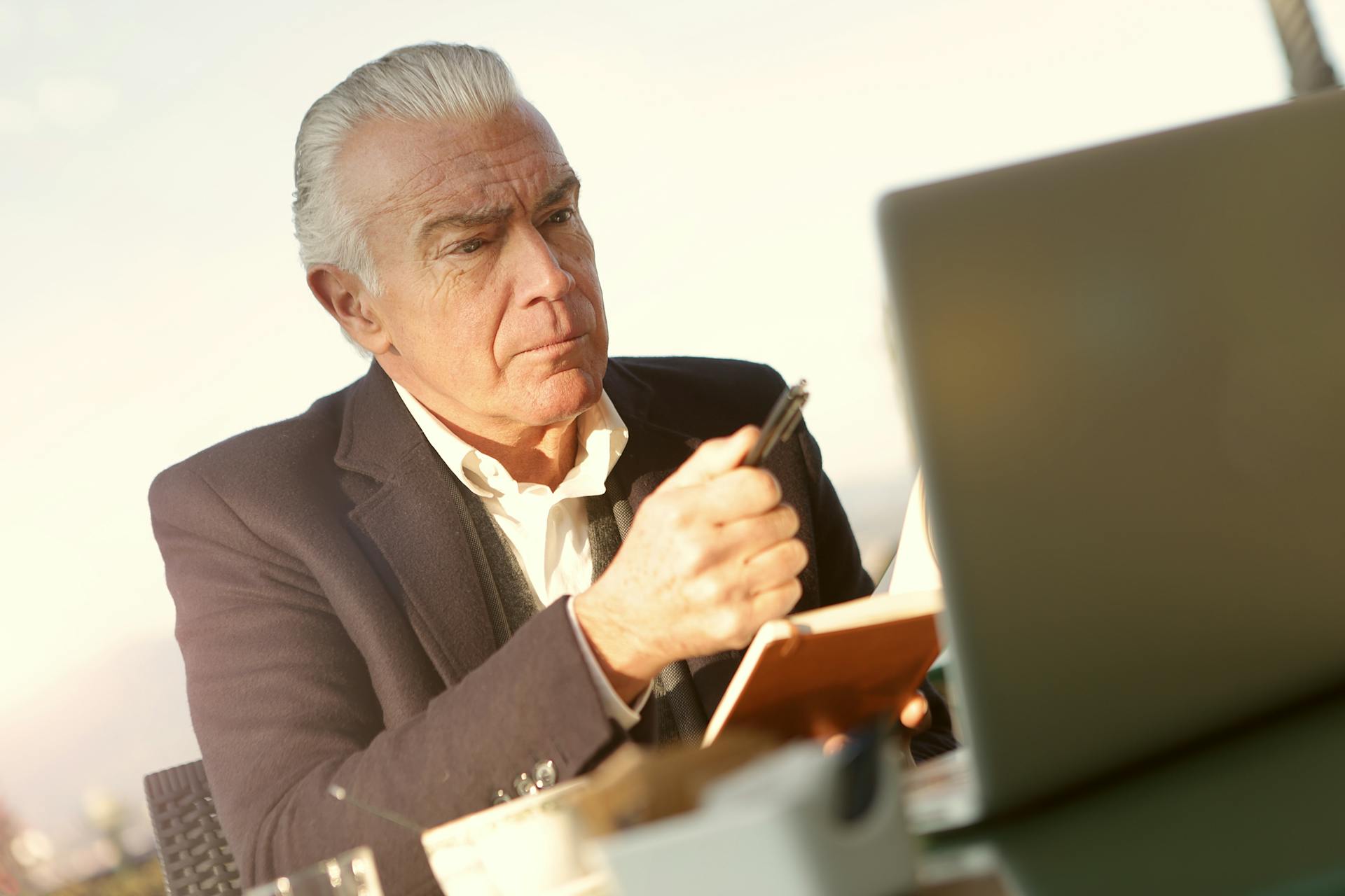 A stern older man sitting in front of his laptop in his office | Source: Pexels