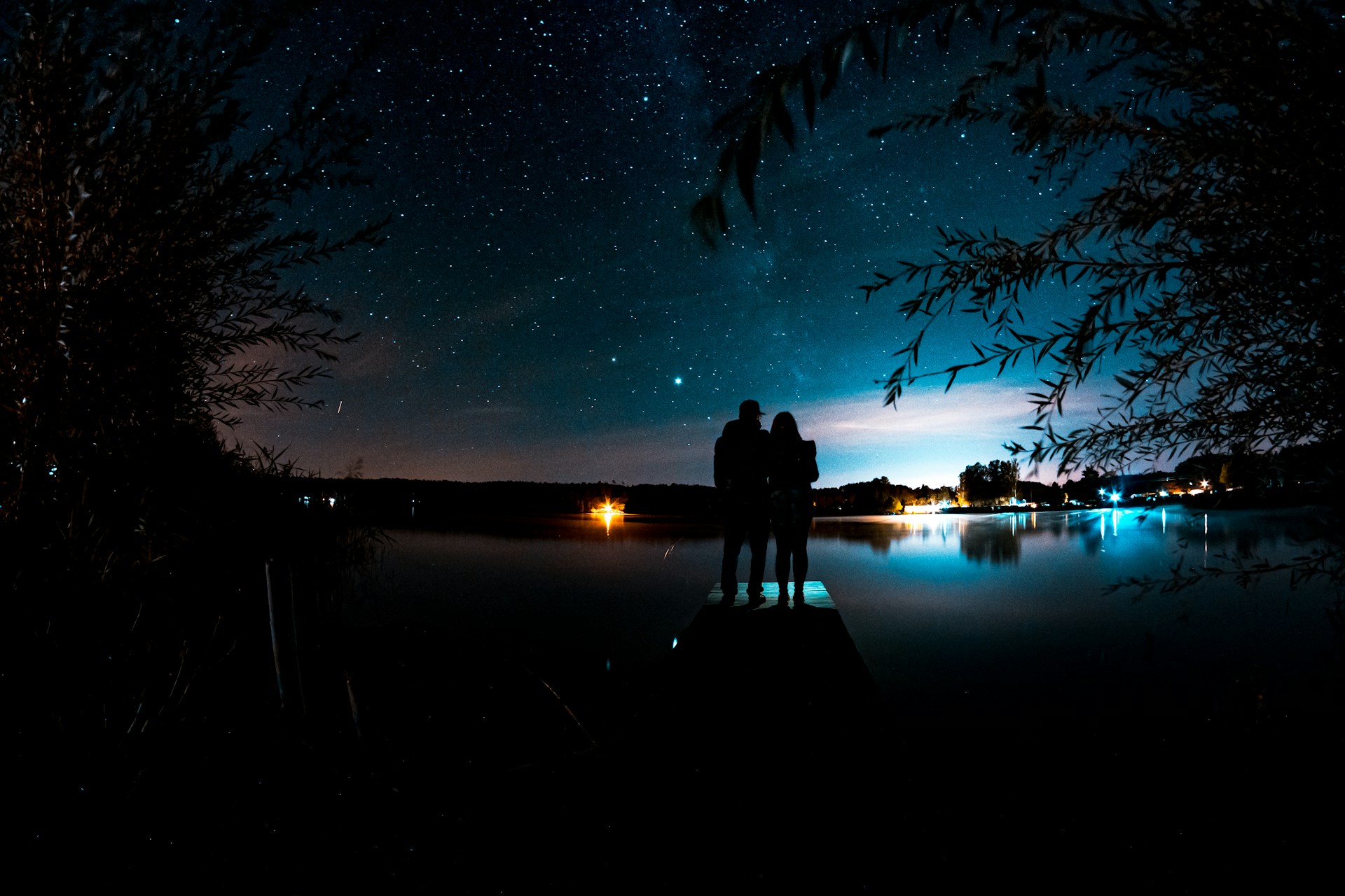 A young couple admiring the stars from a pier on a scenic evening | Source: Unsplash