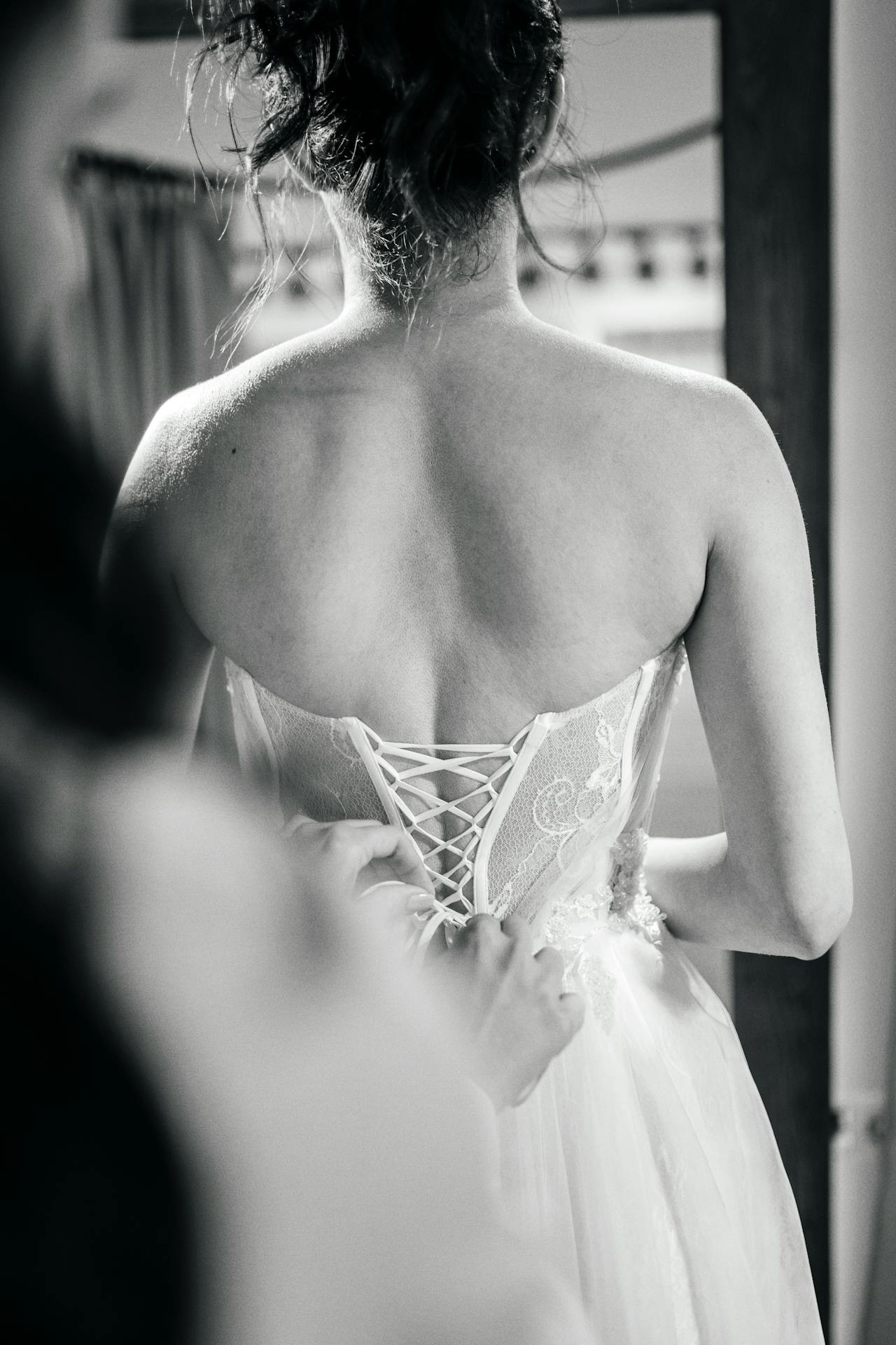 A woman helping a bride with her dress | Source: Pexels