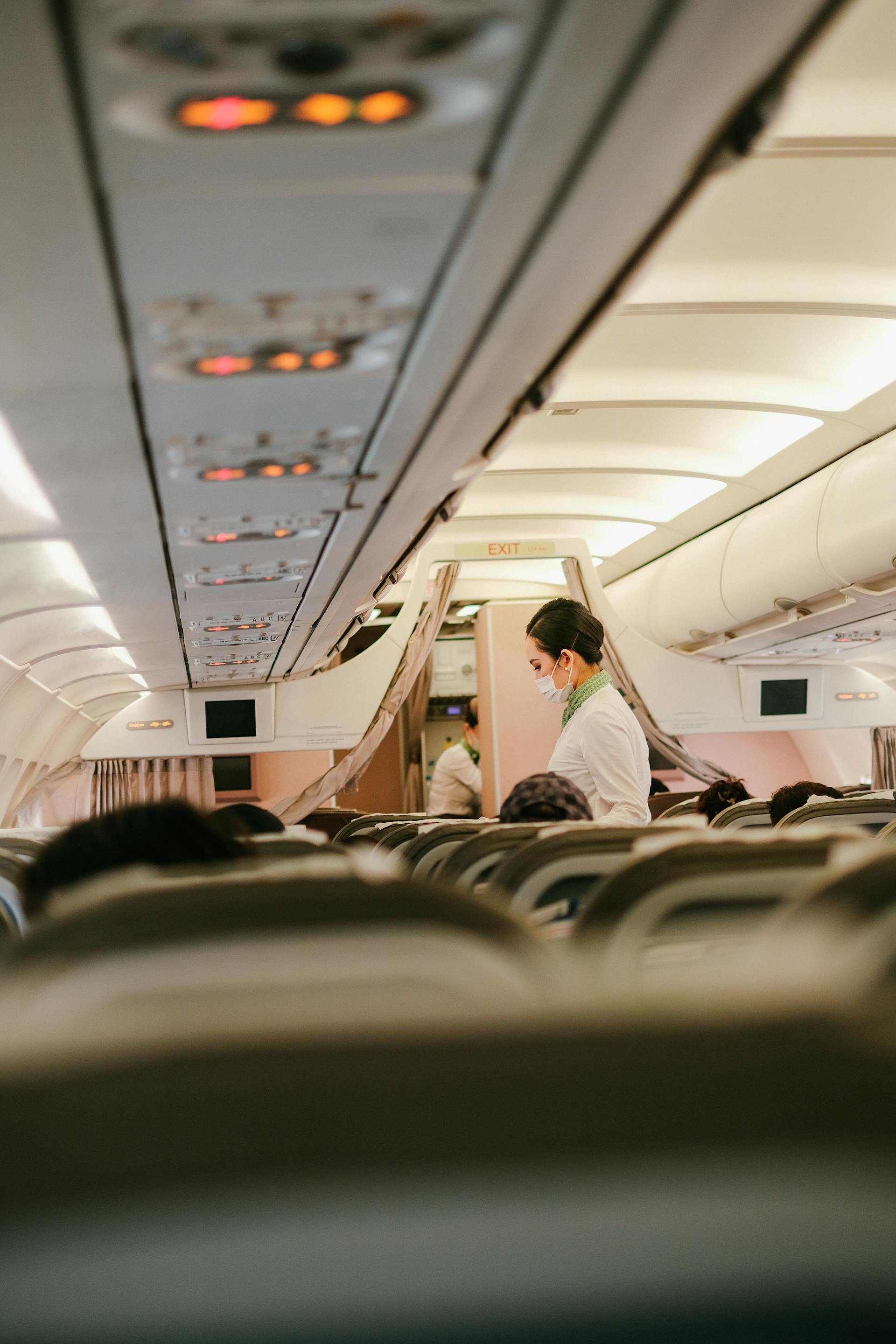 A flight attendant standing near people sitting in airplane seats | Source: Pexels